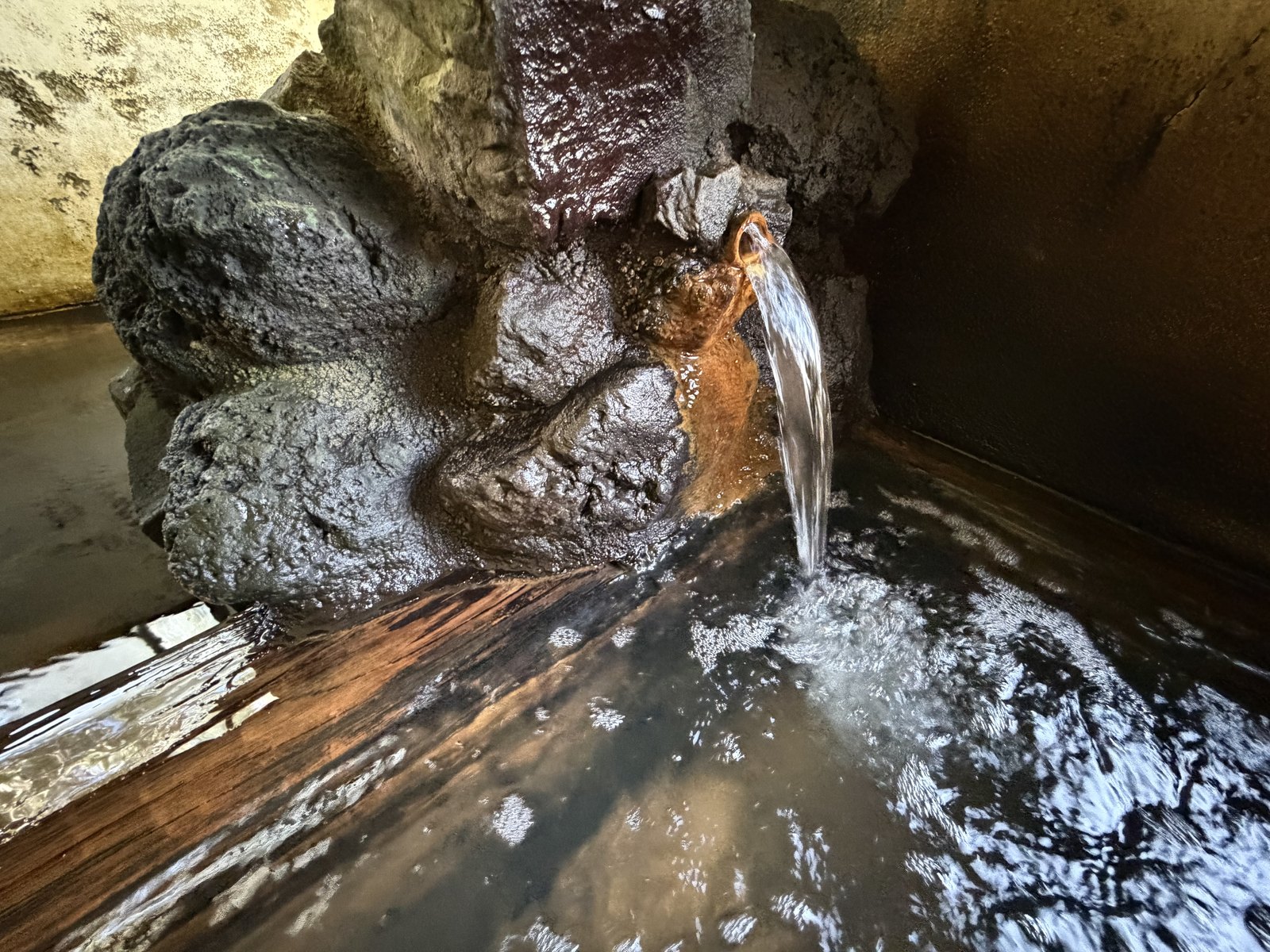 登喜和荘 内湯の湯口・岩と木樋から落ちる源泉