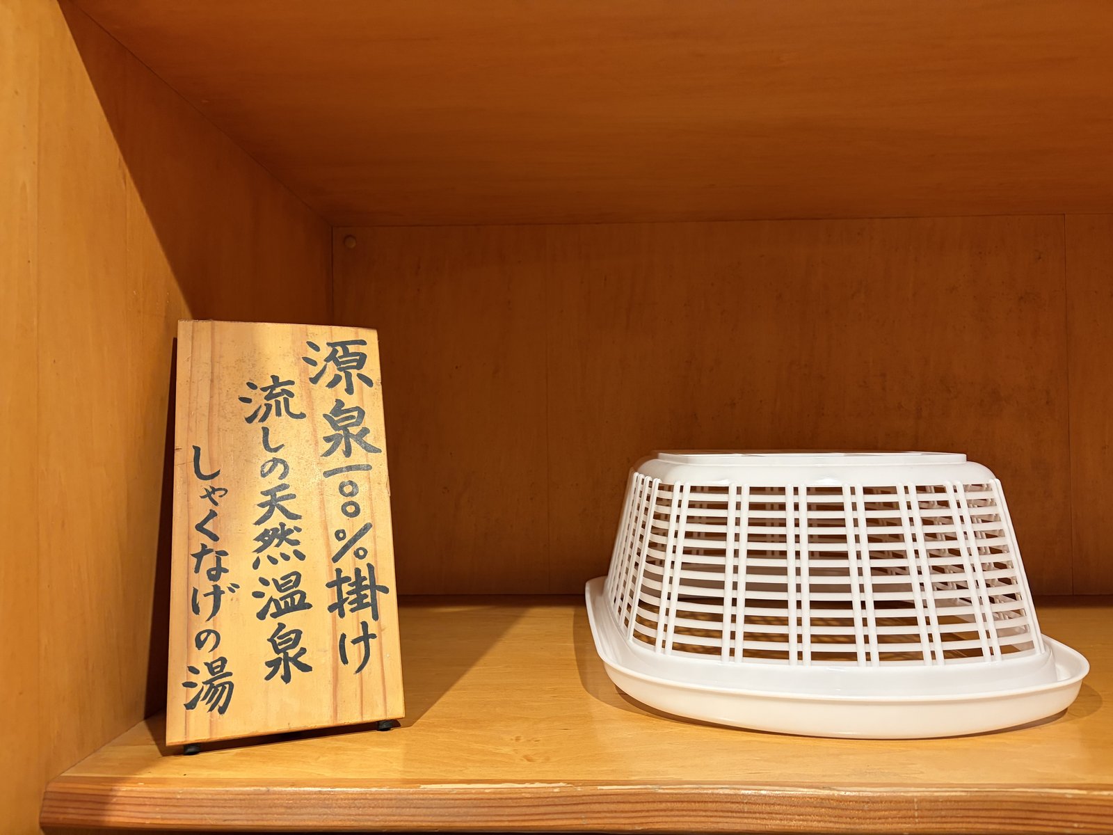 館内に置かれた「源泉100%掛け流しの天然温泉 しゃくなげの湯」木製案内+湯桶