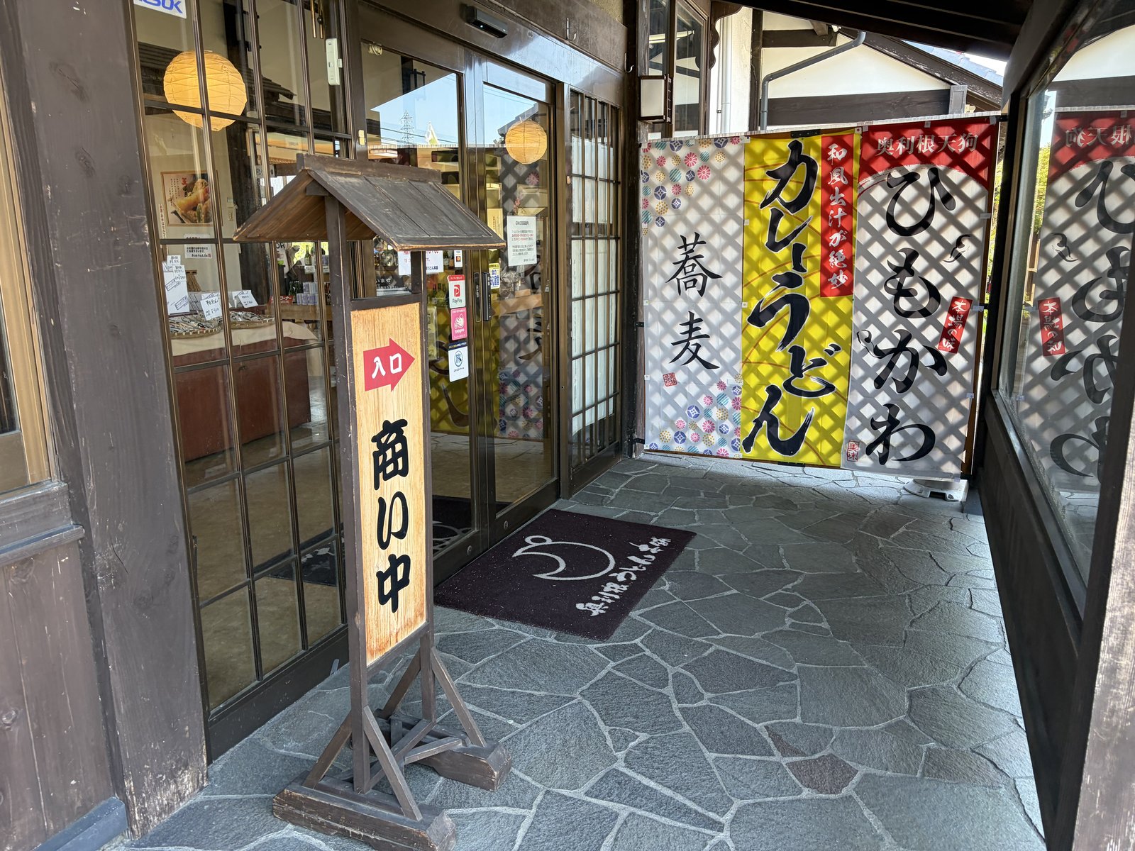 入口・「ひもかわ」「カレーうどん」「蕎麦」幟+「商い中」看板