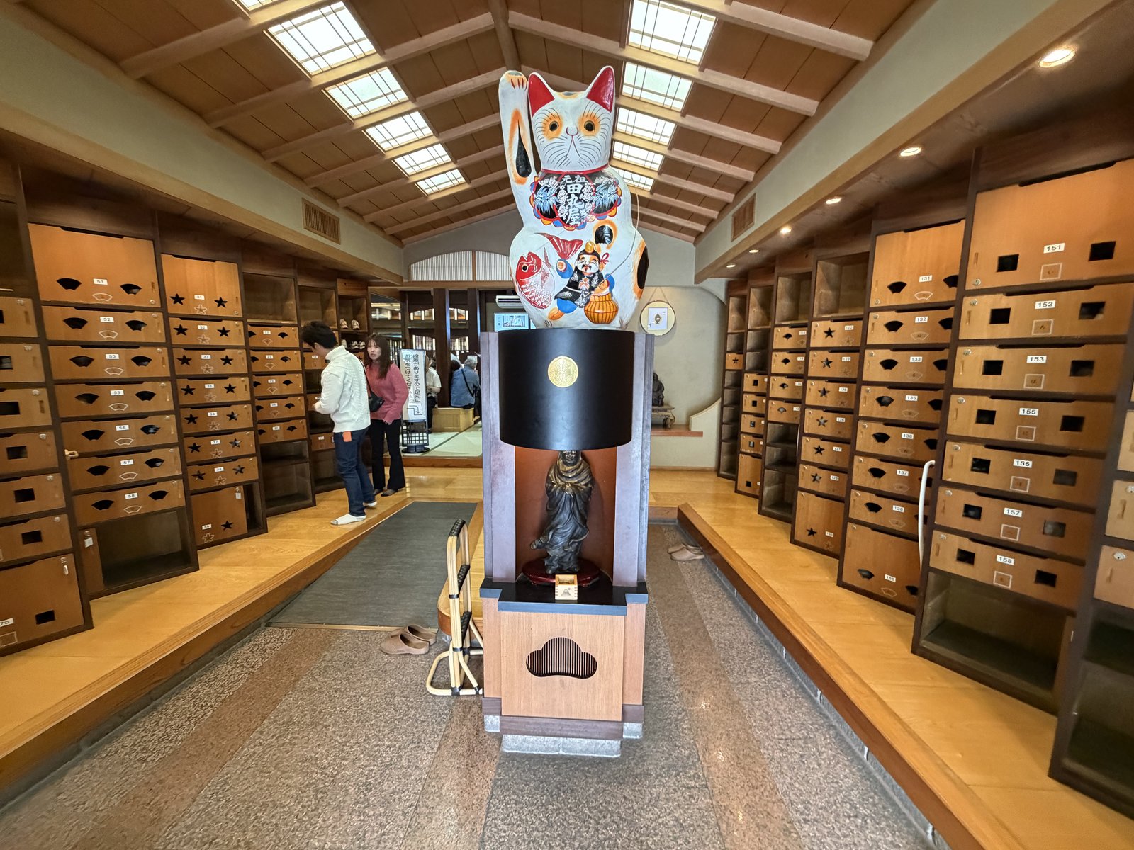 巨大な招き猫が中央に立つ・両側に下足箱・天窓