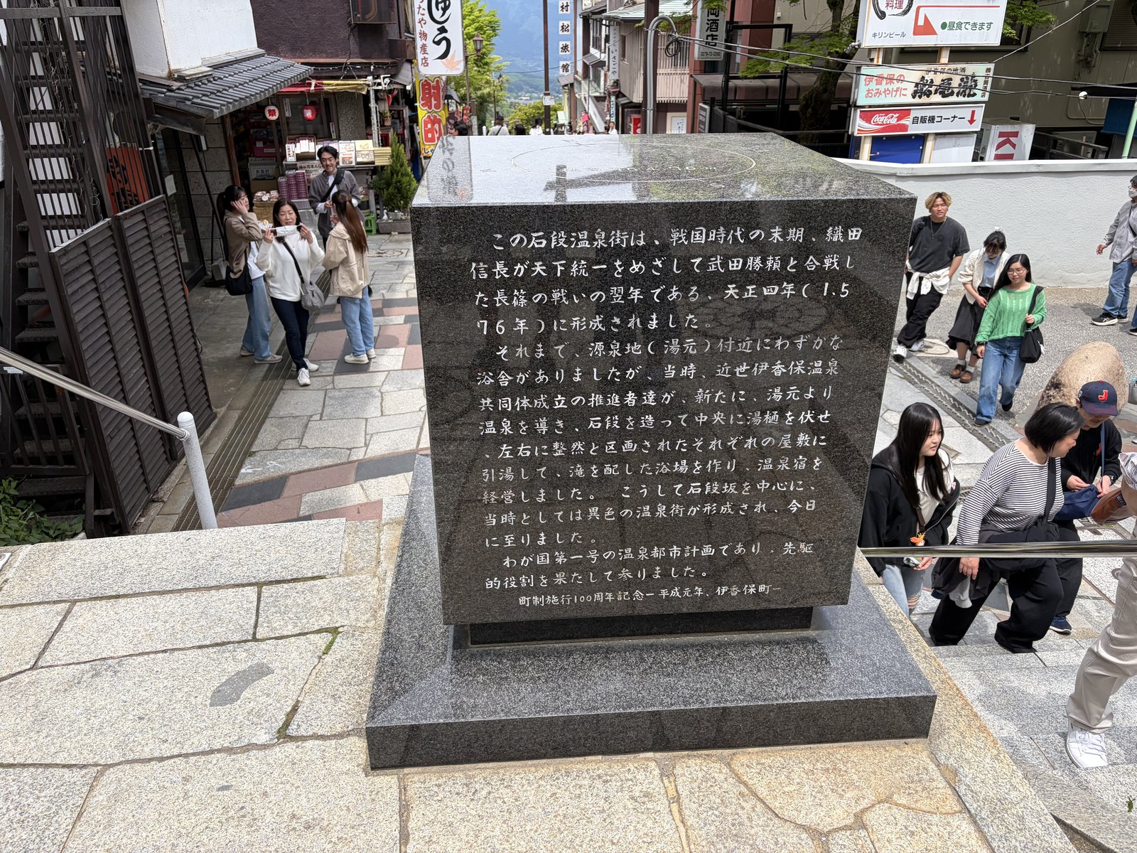 石段街の歴史を刻んだ石碑・観光客が読んでいる
