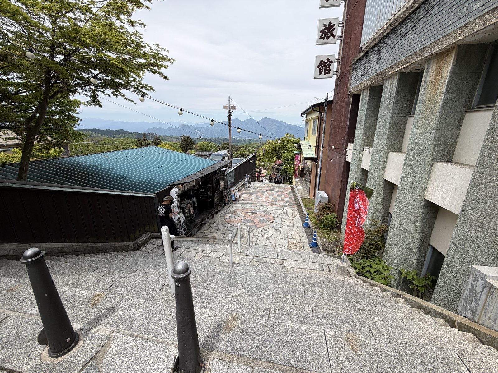 建物の少し上から石段街と山並みを見下ろす