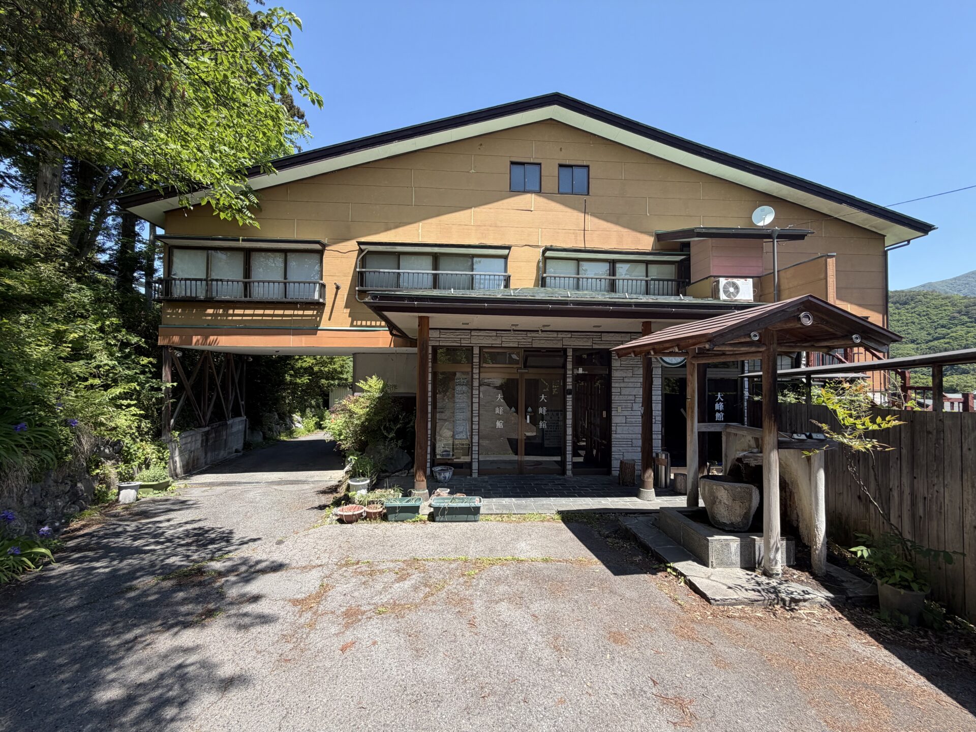 外観全景・みなかみ旅館らしい黄色い壁と山