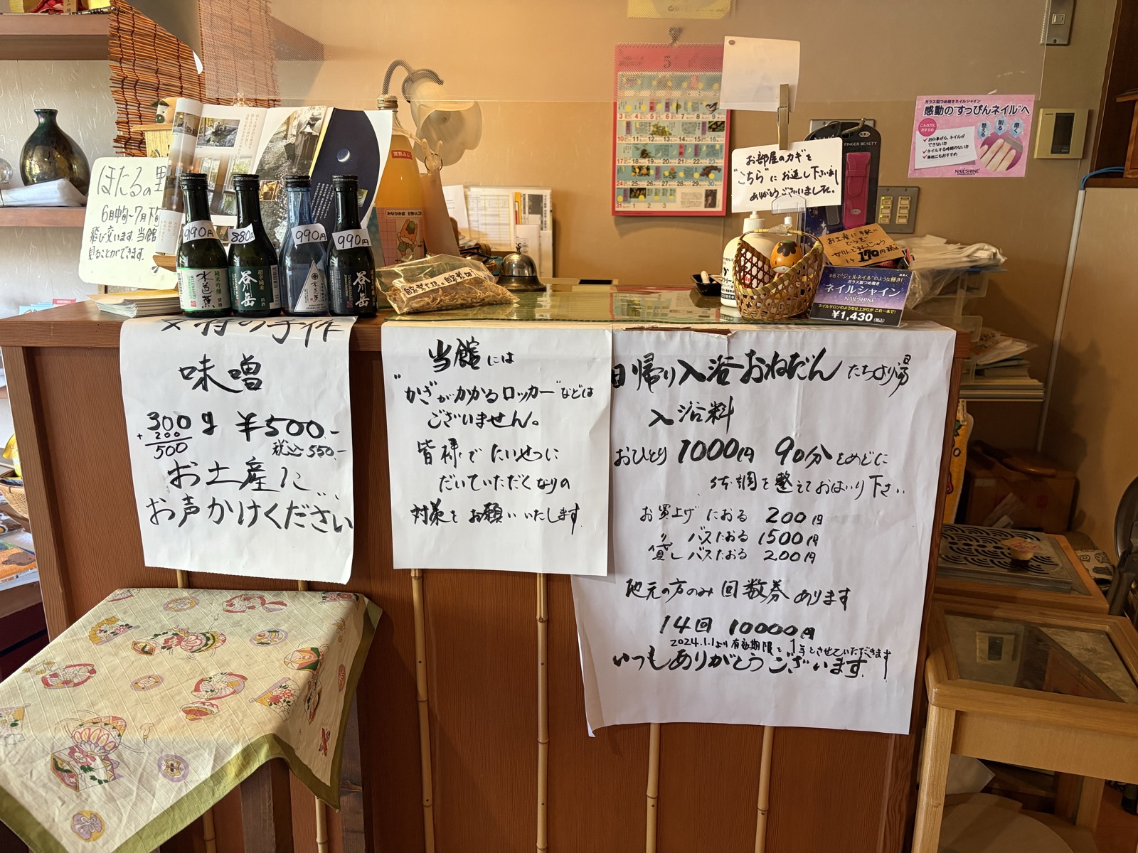 帳場の張り紙「日帰り入浴 おひとり1000円 90分目安／鍵つきロッカーなし／回数券14回1万円」