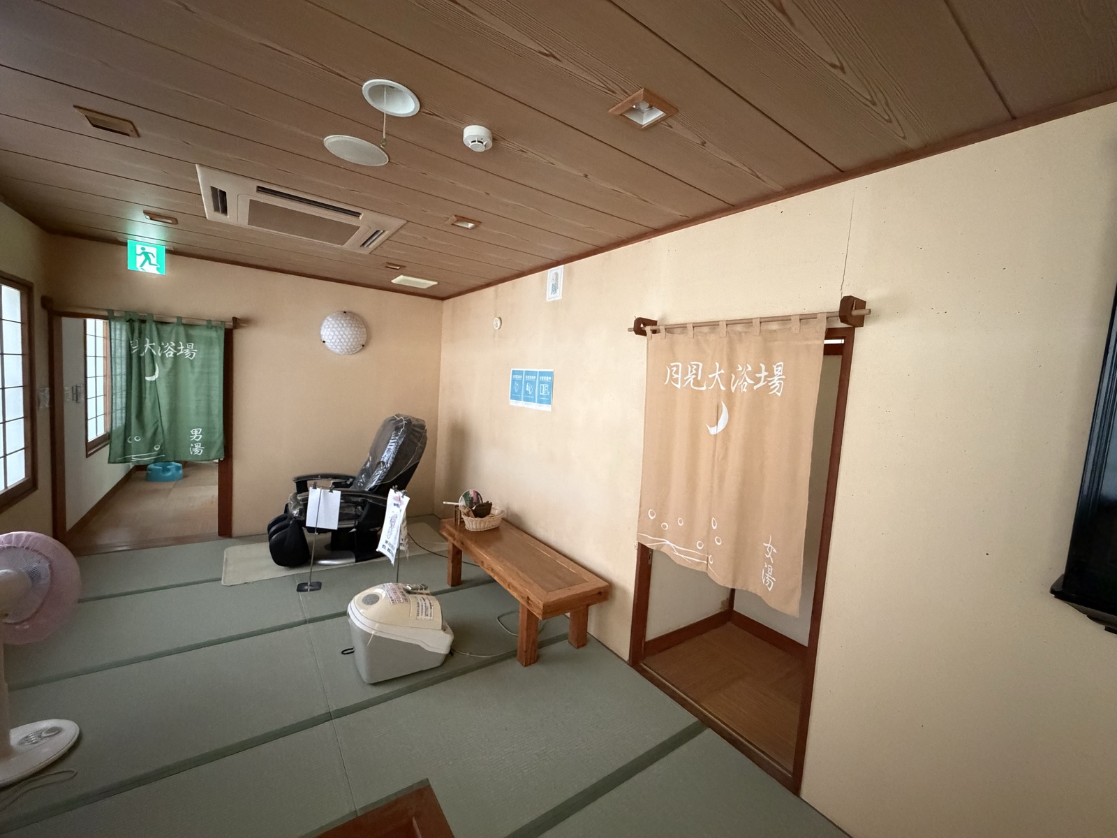 脱衣所の前室・暖簾の前の広い畳張り、マッサージチェアと扇風機
