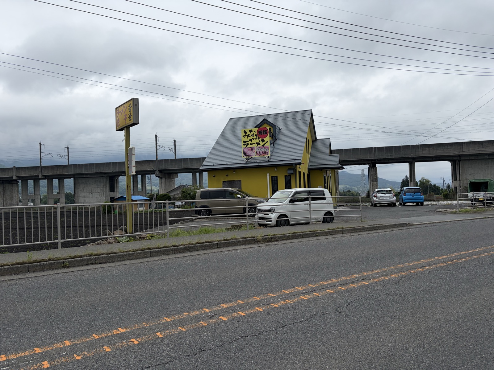 香華 道路向こうから見た外観・隣の高架橋(関越自動車道)と並ぶ