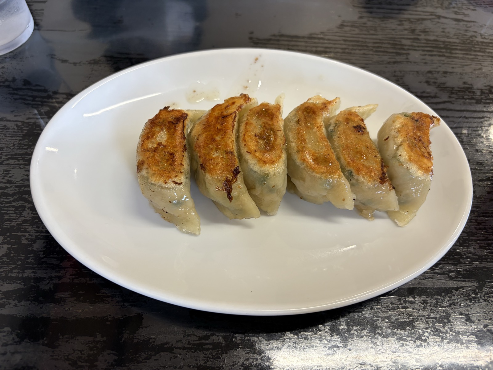 焼餃子 500円・白い楕円皿に焼き目がきれいに揃った餃子6個が並ぶ
