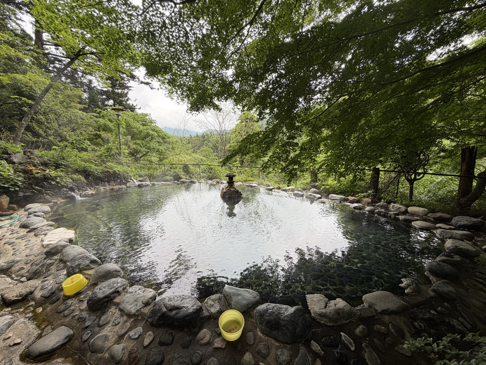 男湯野天風呂・全景・湯口の岩が中央に立ち、奥に山が抜ける