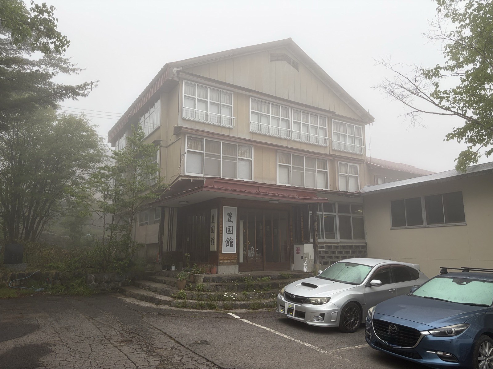 霧に包まれた豊国館の木造の外観