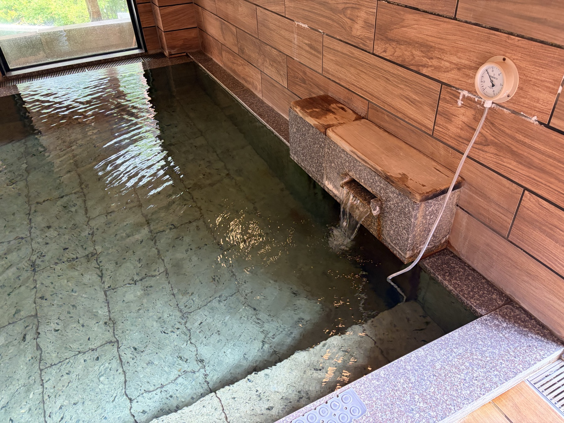湯口には温度計。高温の源泉を加水して適温に整えている