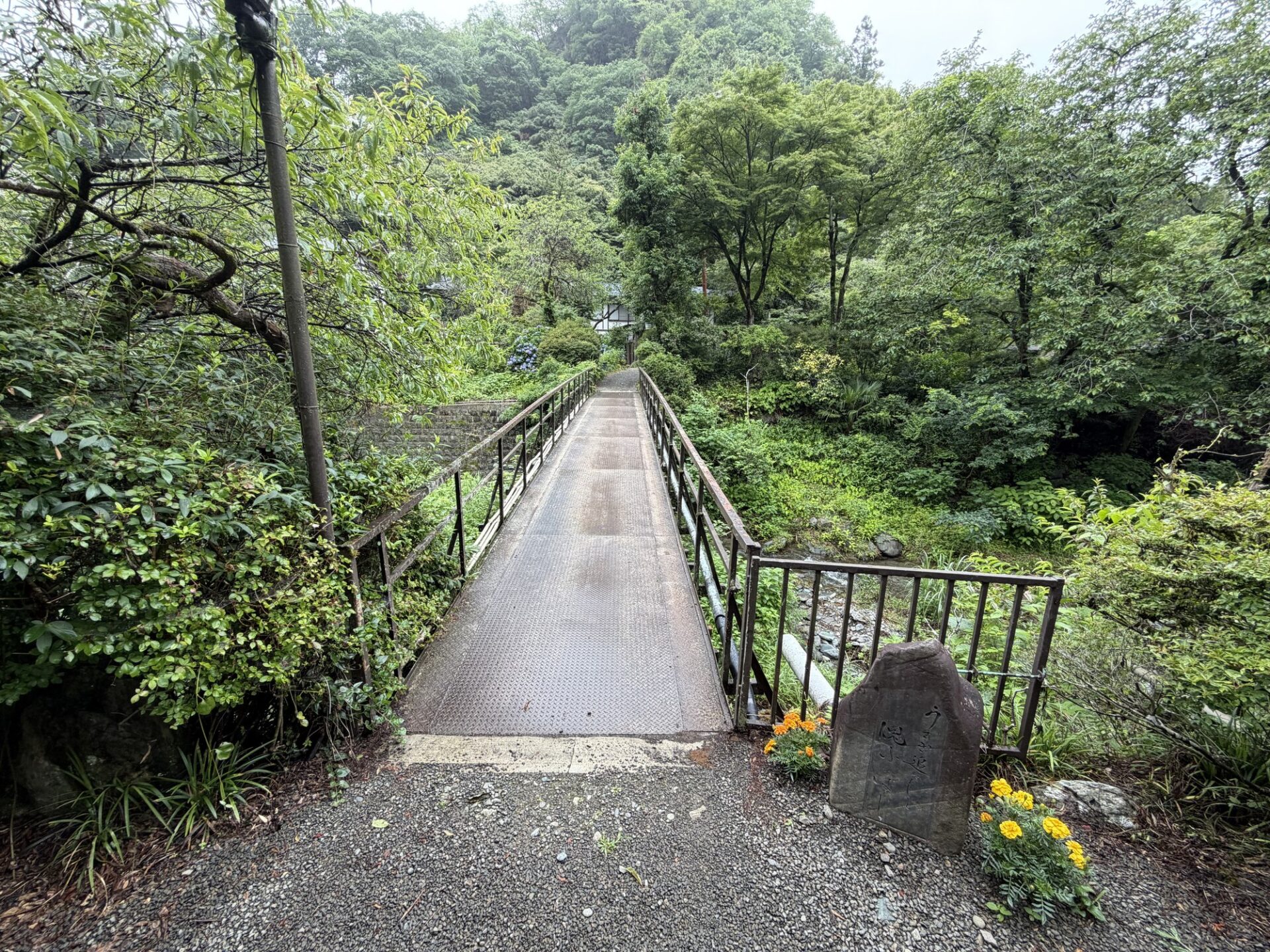 駐車場から渡る鉄の橋・石碑・マリーゴールド