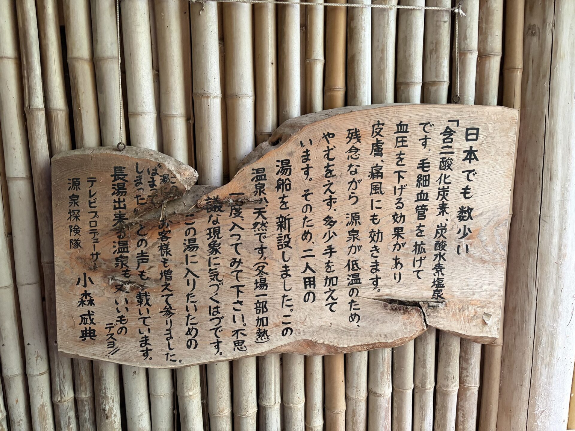源泉への思いが書かれた手書きの木看板