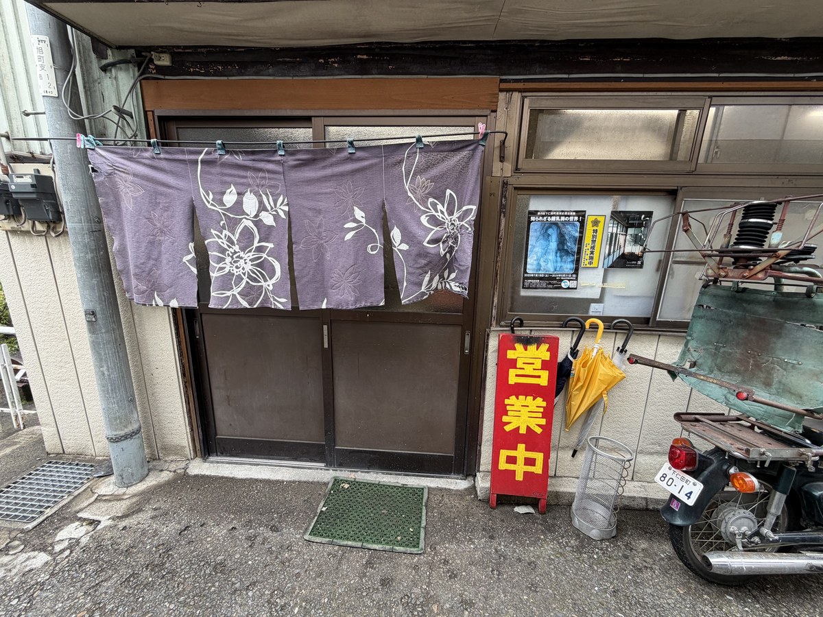 一番の入口。藤色の花柄の暖簾と赤い営業中の看板
