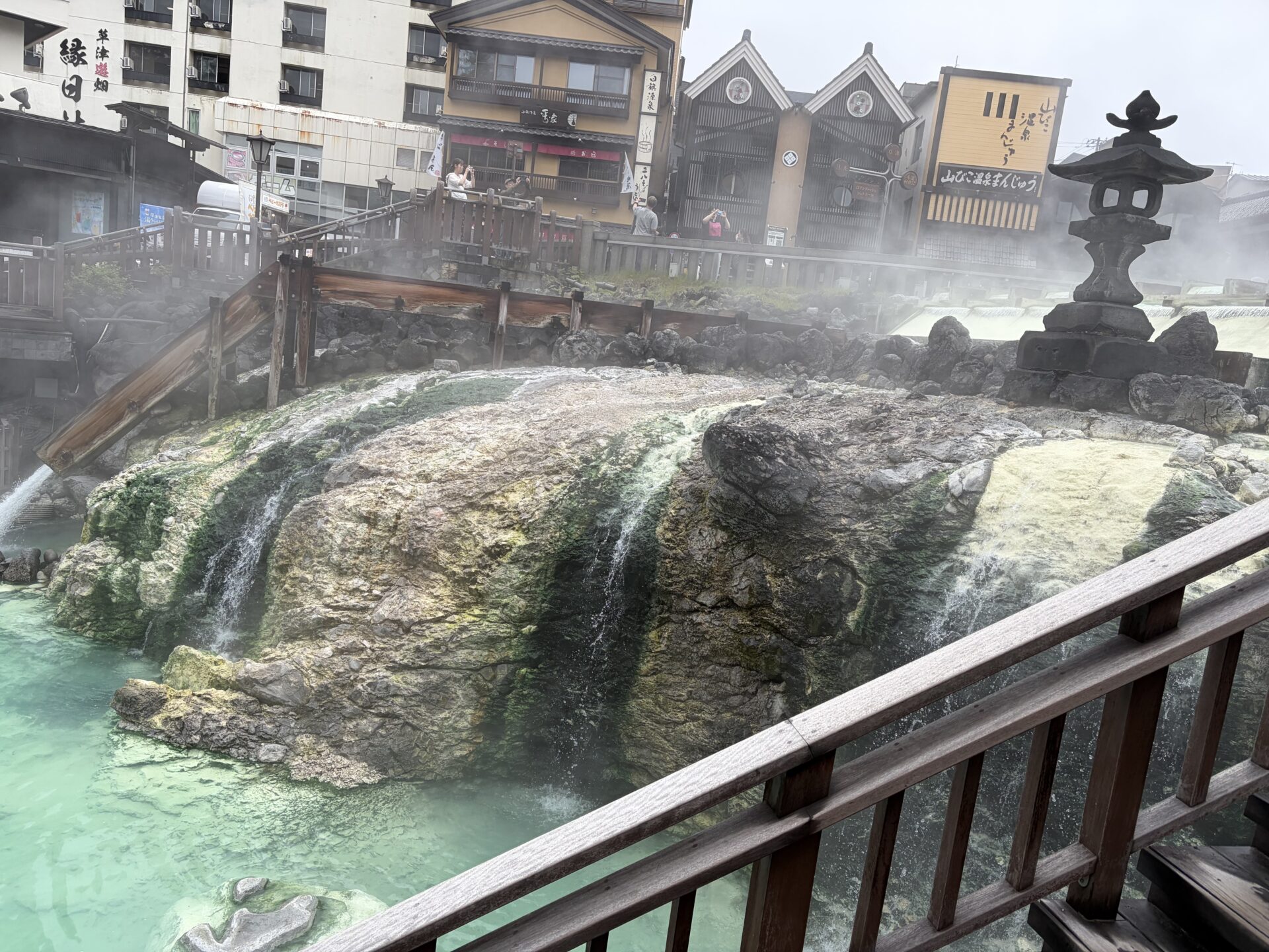湯畑の湯滝。樋を流れ落ちる湯に黄色い湯の花が析出（成分が固まって表面に出てくること）している