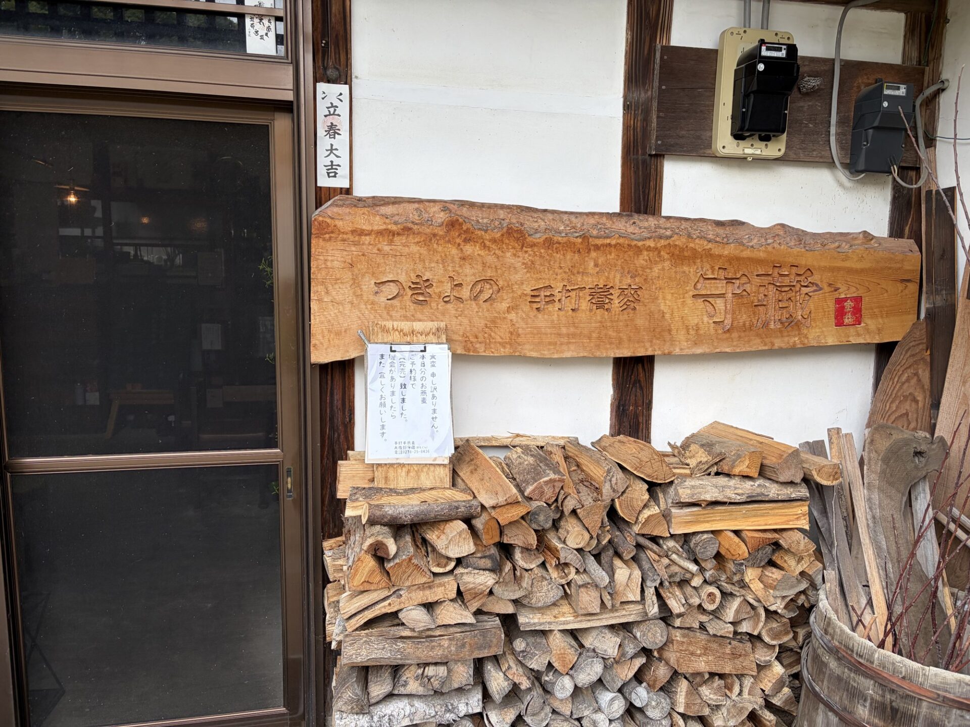 「つきよの 手打蕎麦 守藏」と彫られた一枚板の看板