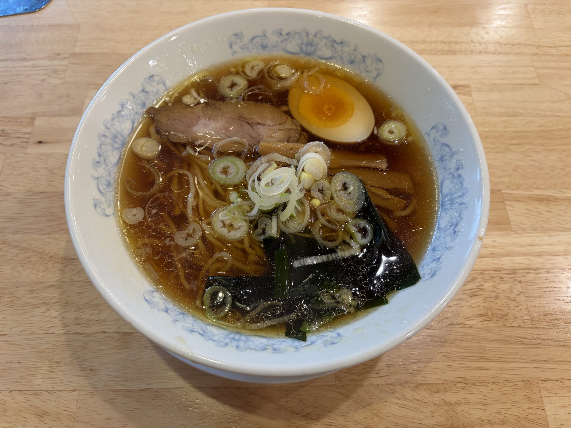 満洲しょうゆラーメン。澄んだ醤油スープにわかめ・メンマ・刻みねぎ・チャーシュー・半熟味玉