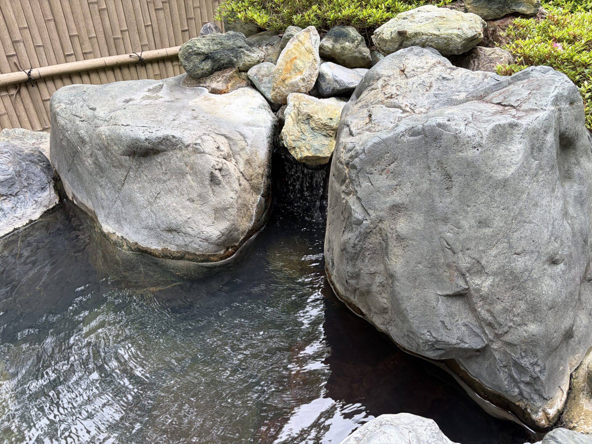露天の岩のあいだから流れ込む湯。湯面はやわらかく澄んでいる