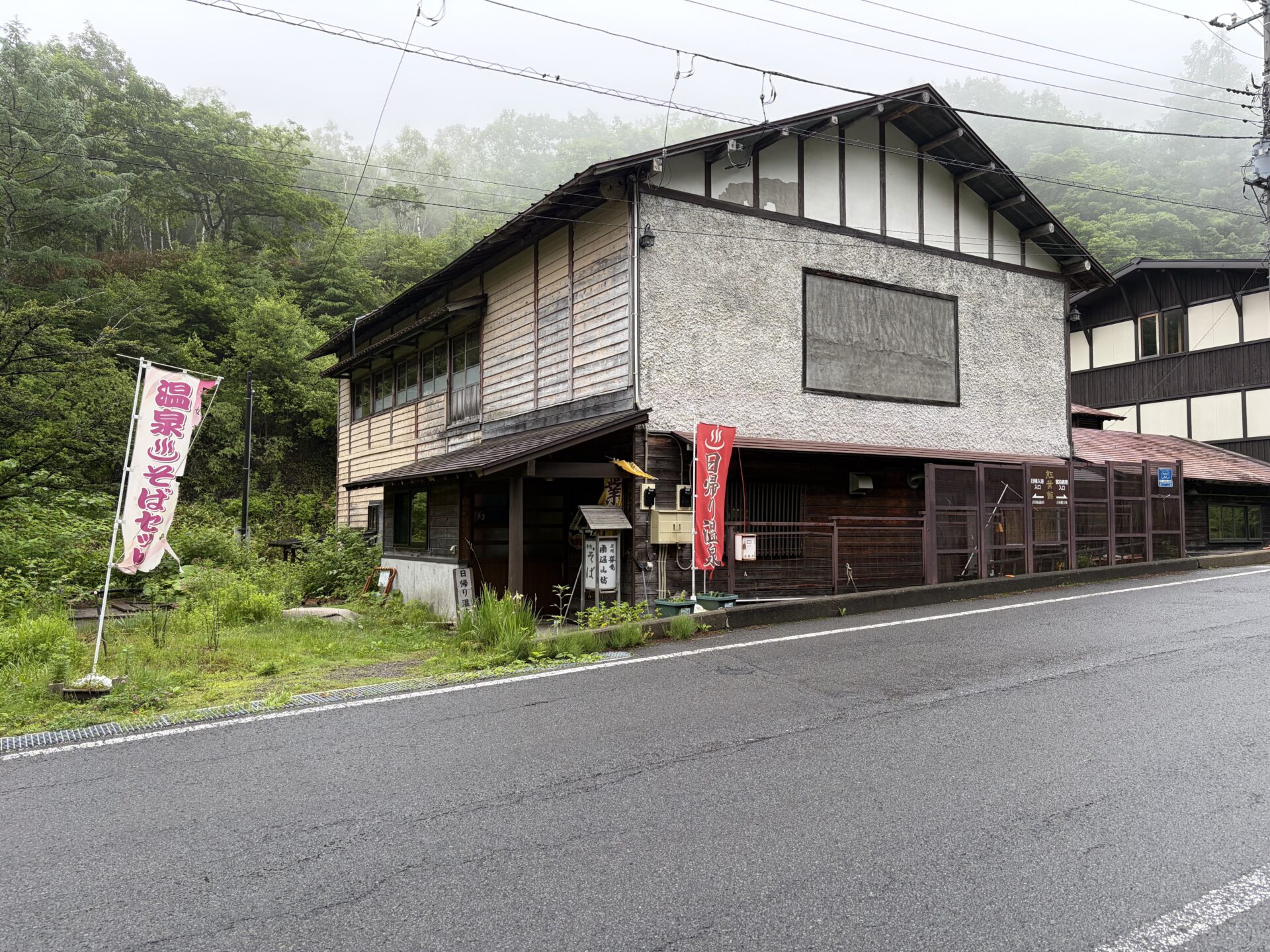 道路沿いに立つ紅葉館の外観。「温泉♨そばセット」と「日帰り温泉」ののぼり
