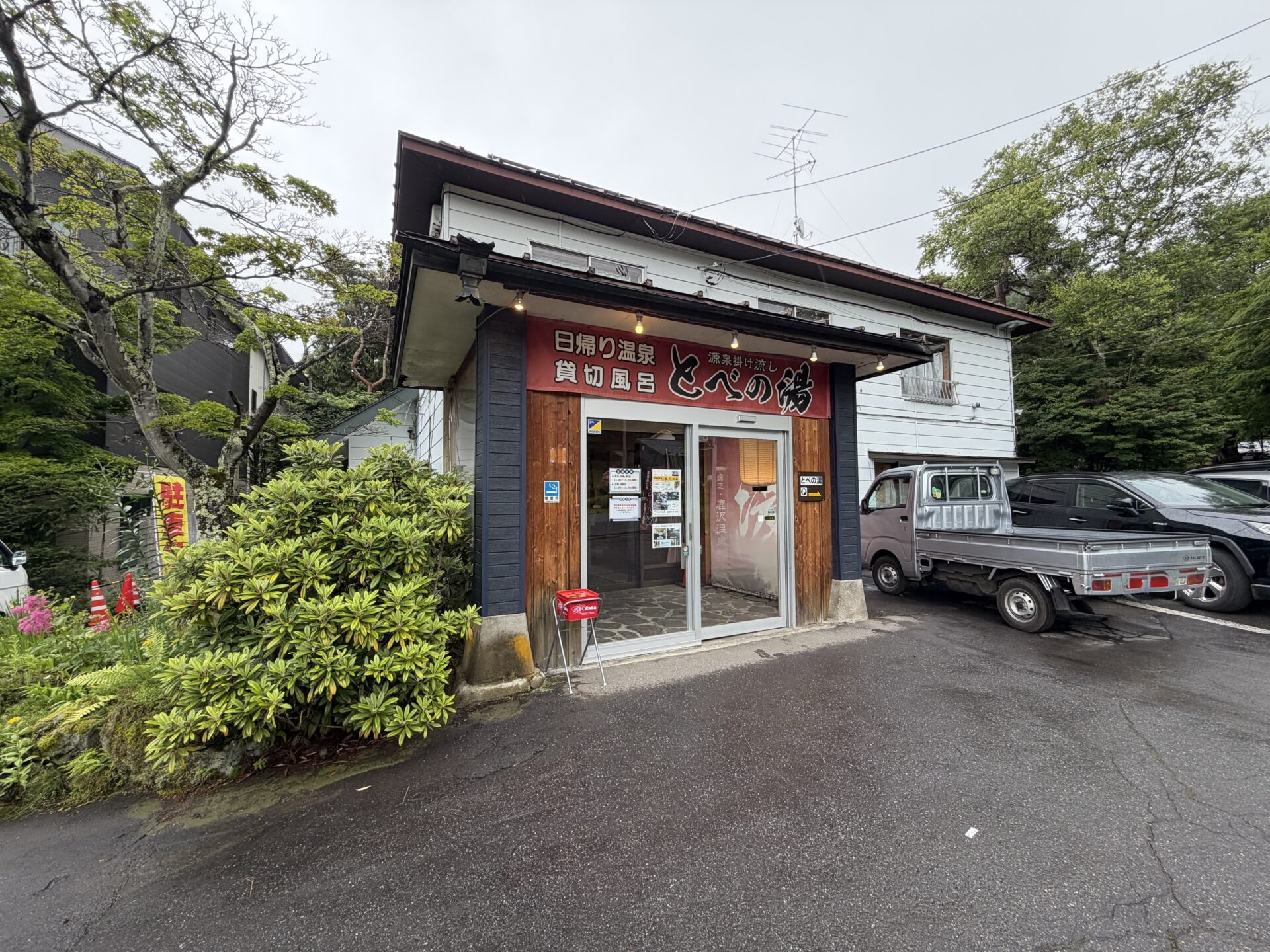 とべの湯の外観。「日帰り温泉／貸切風呂／源泉掛け流し」の赤い看板