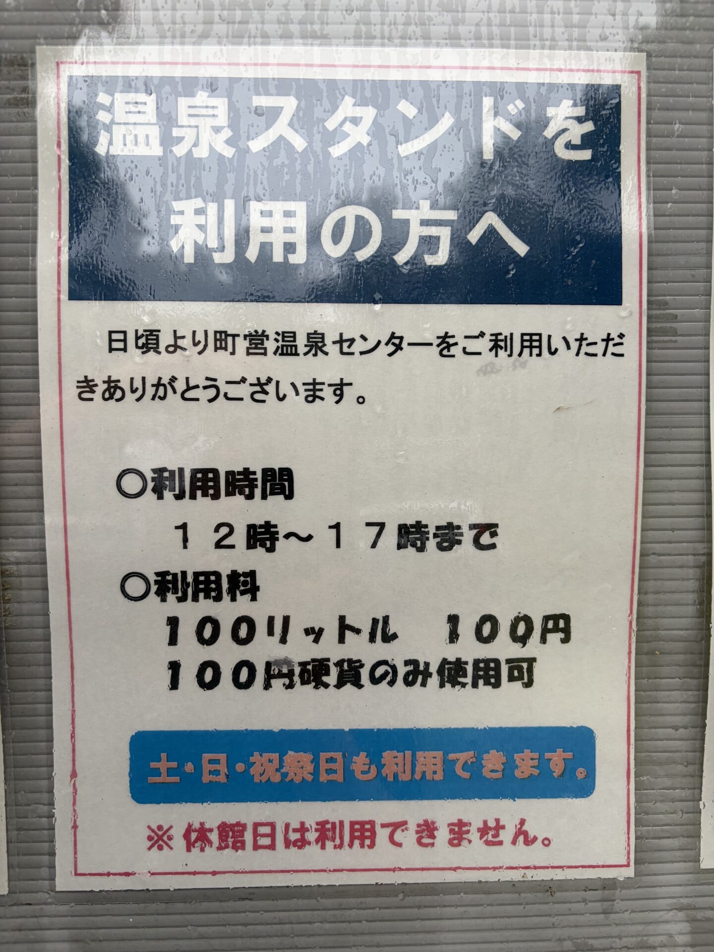 温泉スタンドの利用案内。100リットル100円、12〜17時、100円硬貨のみ