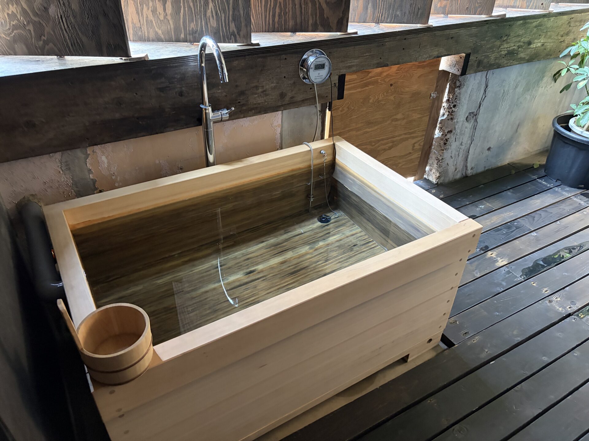 檜の箱型水風呂。蛇口から給水、縁に木桶