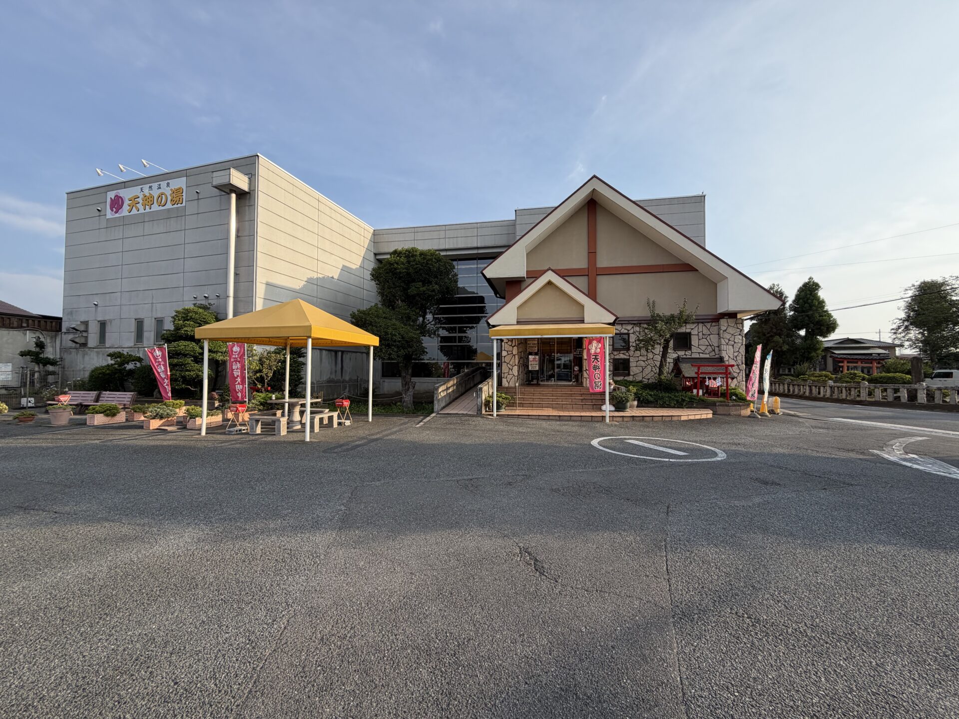 天神の湯の外観。山小屋風の三角屋根と「ゆ」の看板が目印