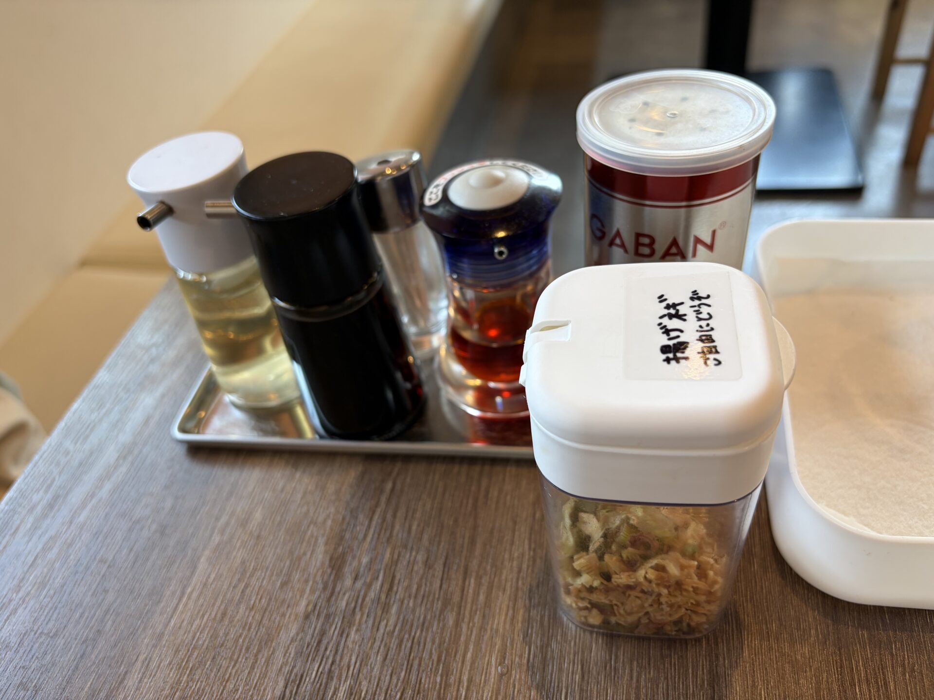 卓上の調味料類。GABANの缶と並んで「揚げ葱 ご自由にどうぞ」の容器
