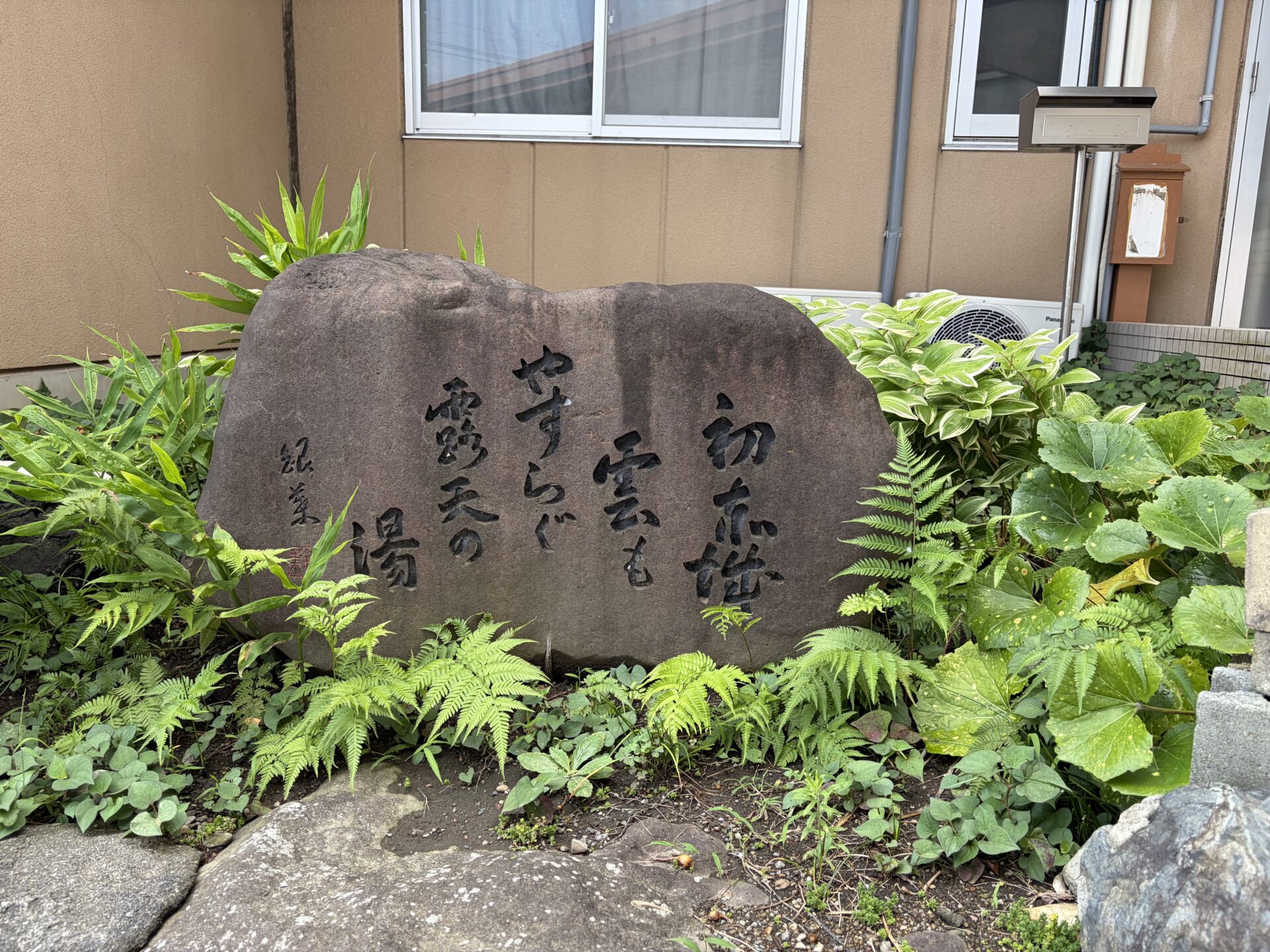 玄関脇の句碑。「初赤城 雲もやすらぐ 露天の湯」