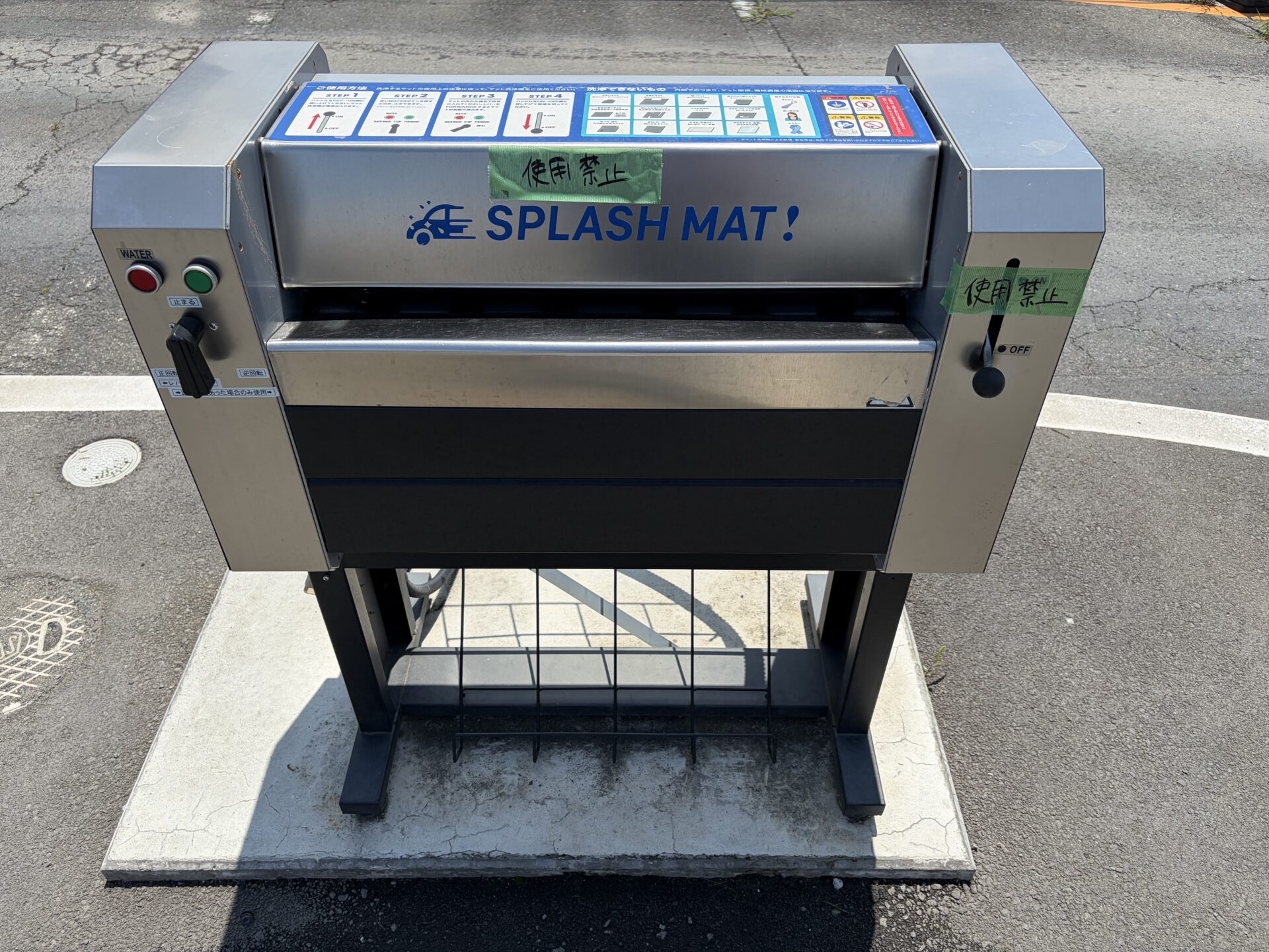 マット洗浄機「SPLASH MAT!」。本体に手書きの「使用禁止」の貼り紙が2枚