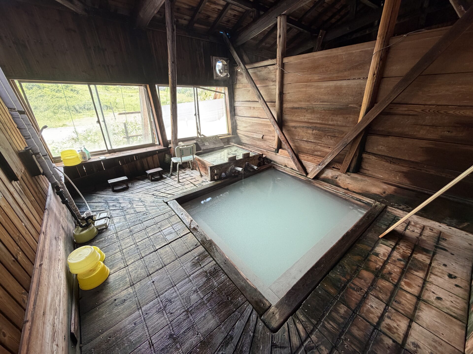 総木造の湯小屋。青白く濁った源泉が満ちる内湯「延寿の湯」