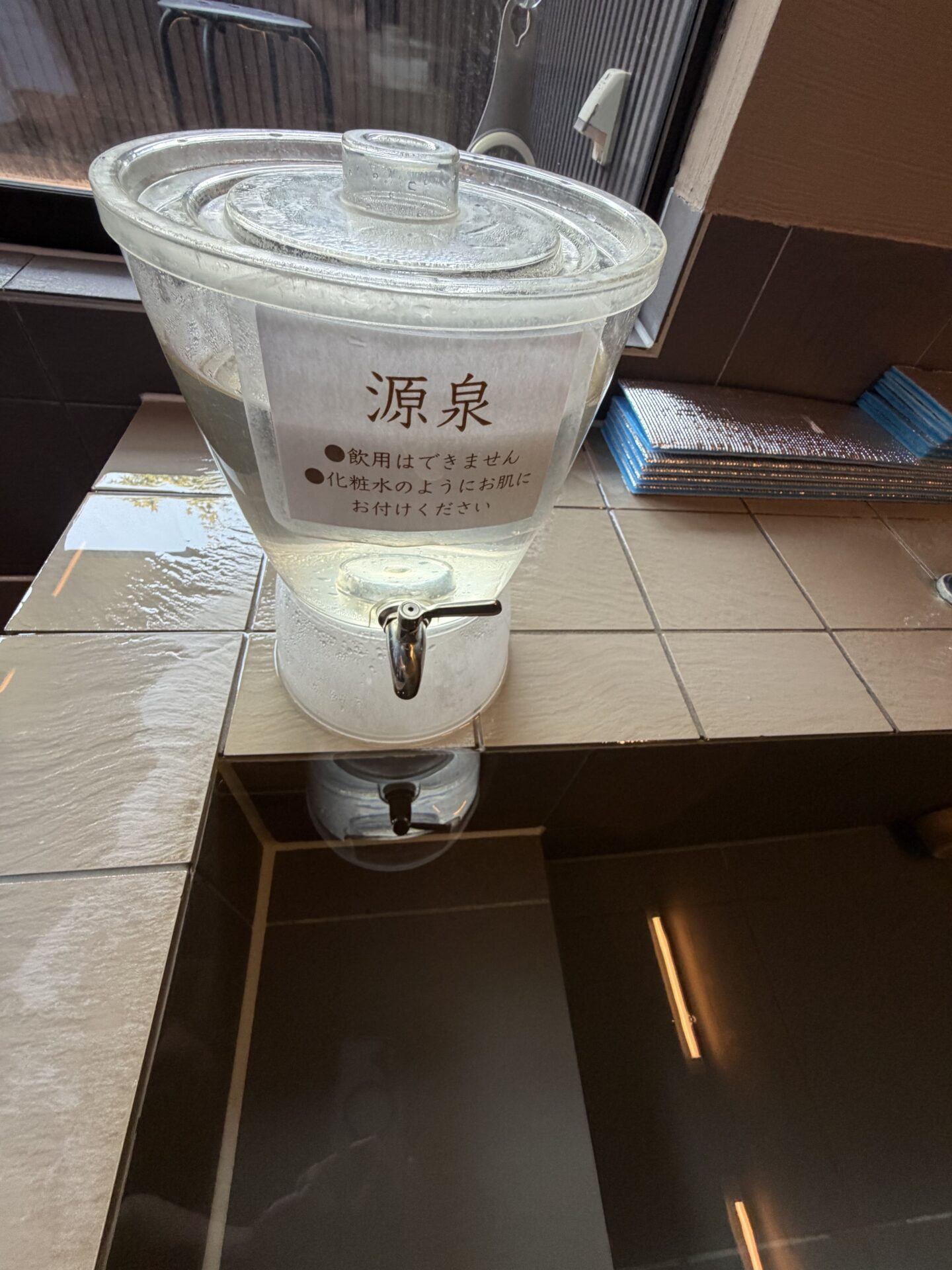 浴槽の縁に置かれた「源泉」ポッド。飲用不可・化粧水のようにお肌に、の注意書き