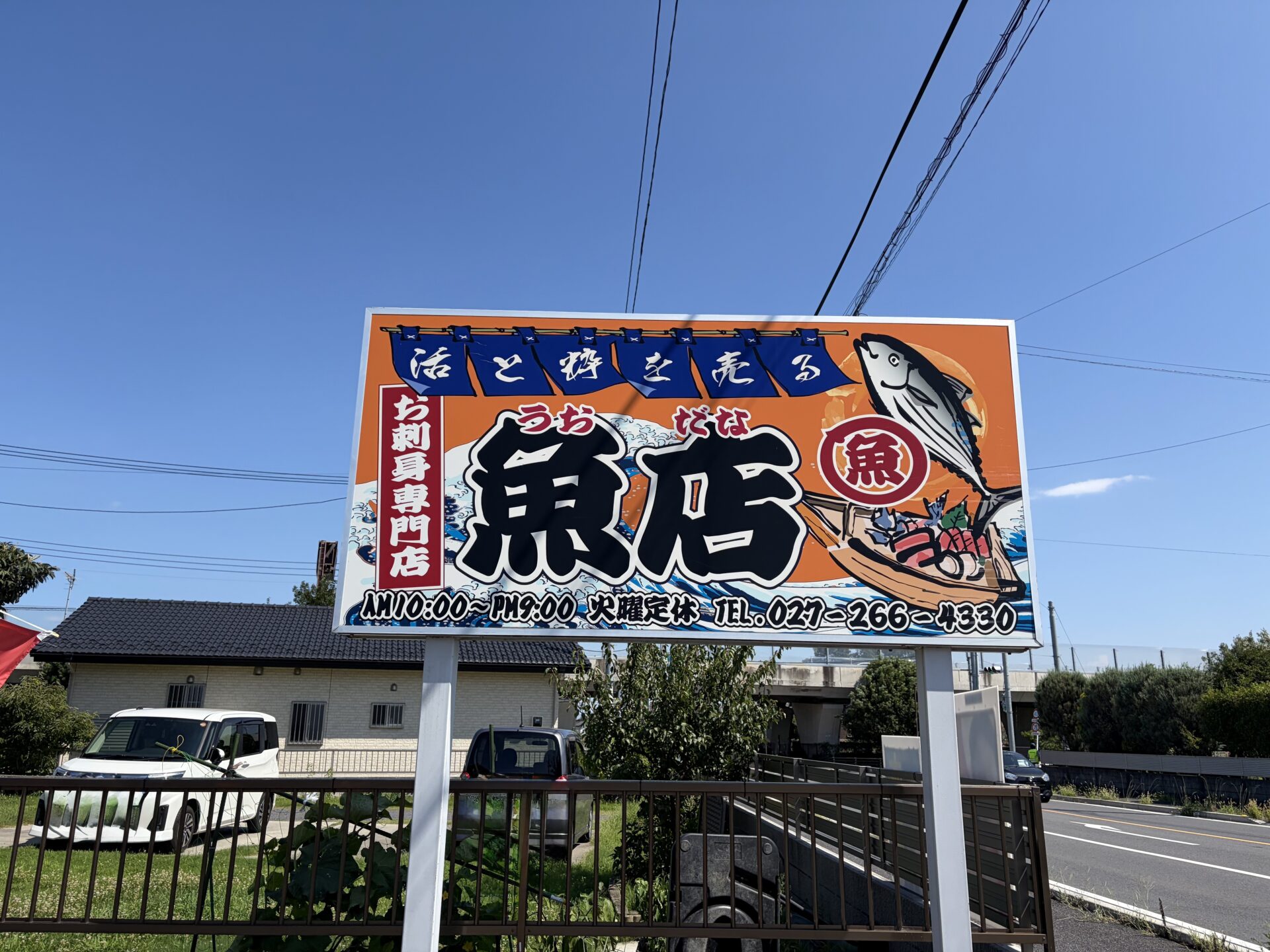 大看板。「活と粋を売る」の筆文字と魚のイラスト