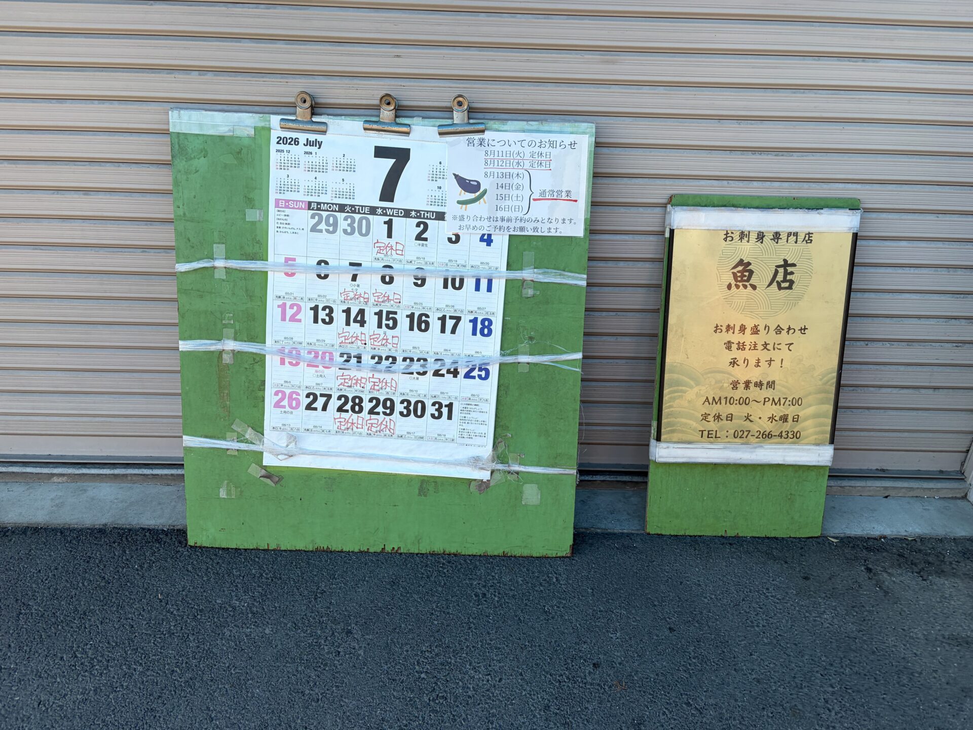 店頭のカレンダー掲示。毎週火・水に赤字で「定休日」。隣に営業時間の金看板