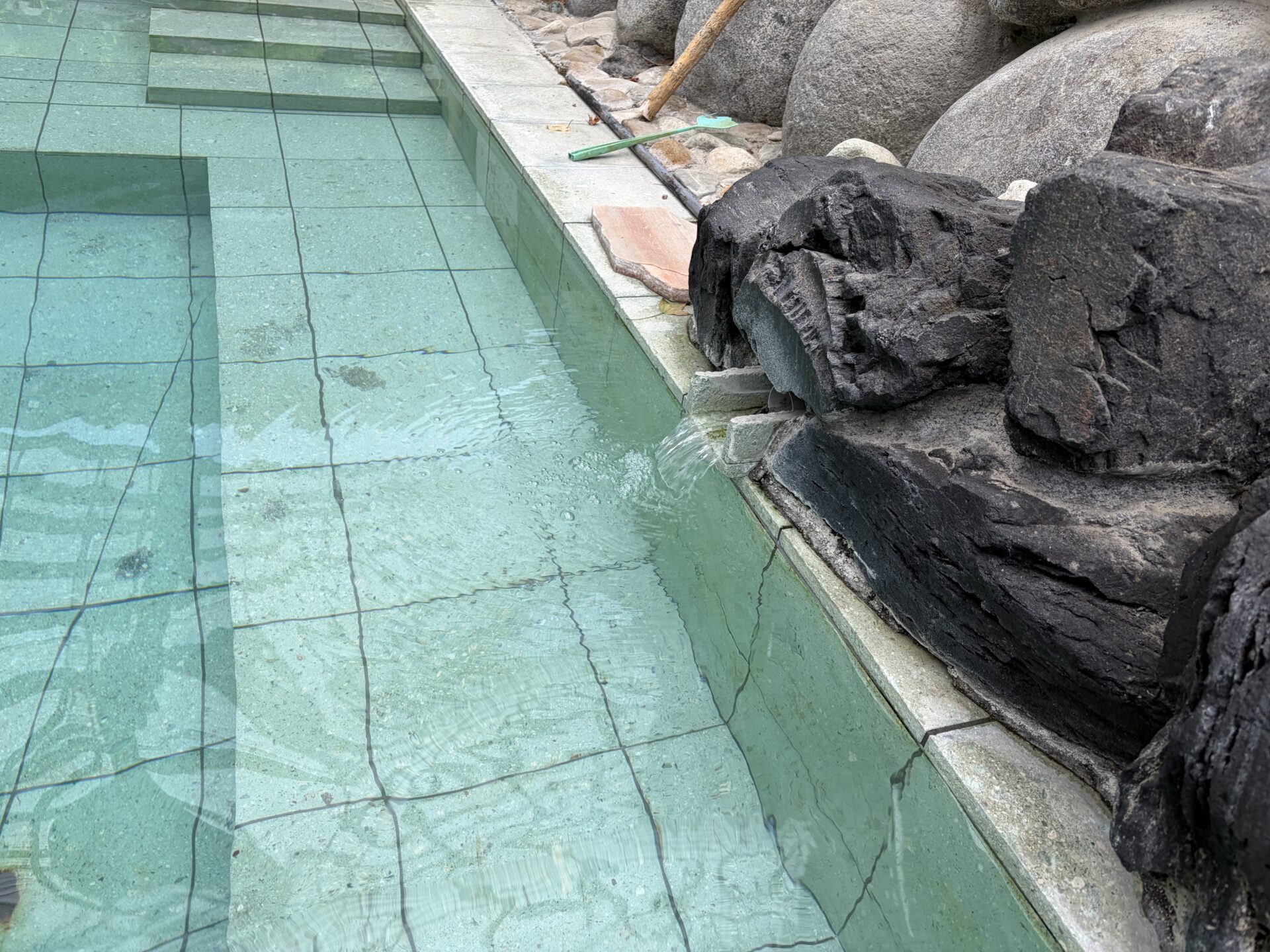 露天の湯口。黒岩の間から源泉が注がれ続ける