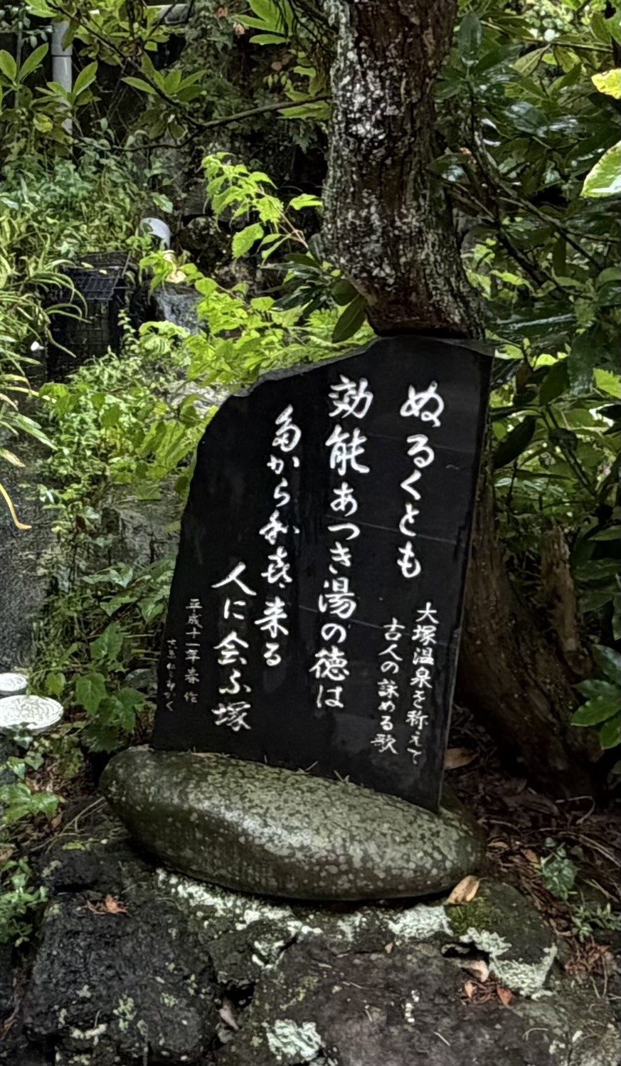 浴場入口の歌碑。「ぬるくとも 効能あつき 湯の徳は」