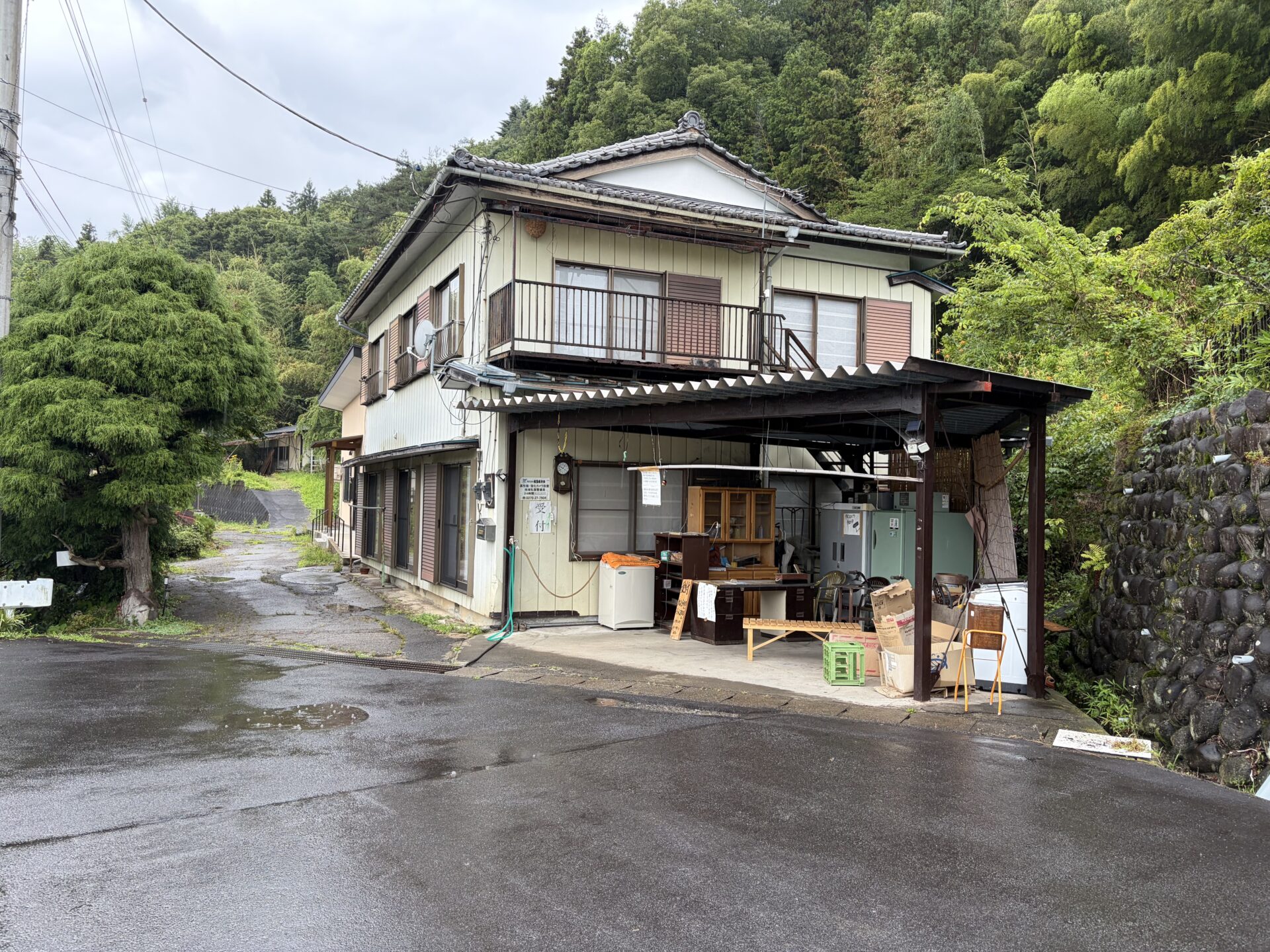 大塚温泉 金井旅館の受付棟。雨上がりの山裾に立つ