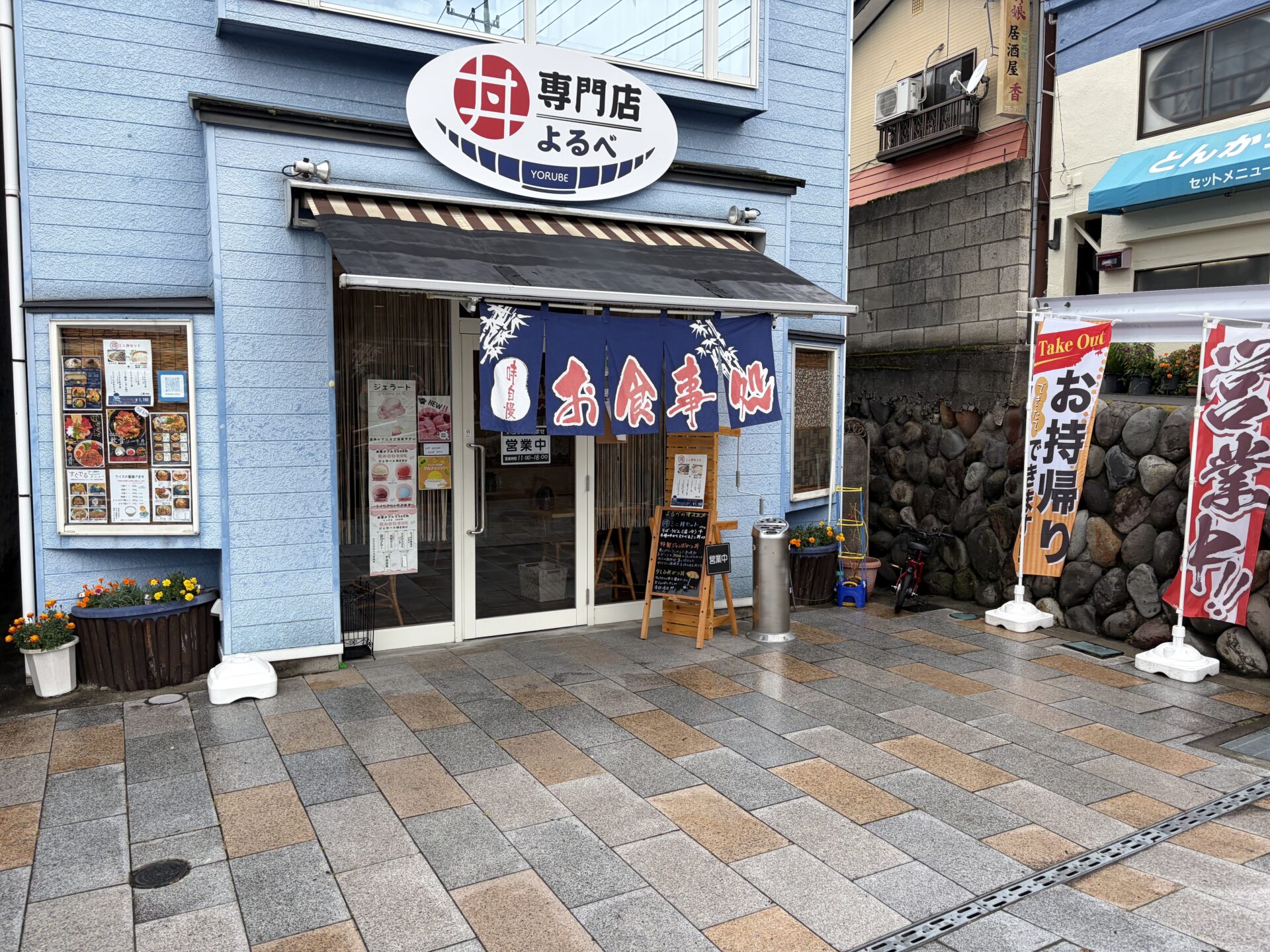 丼専門店よるべの外観。中之条駅前ロータリー脇、青い外壁に「丼」の看板
