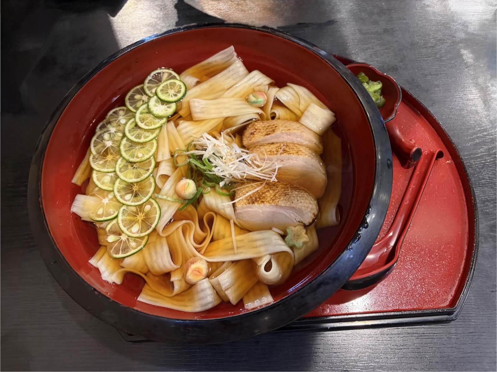 特製鴨汁ひもかわうどん。炙った鴨ロースのスライス、幅広のひもかわうどん、すだちの輪切り、白髪ねぎ