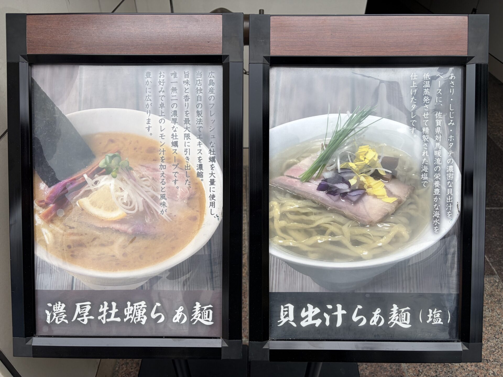 店頭のショーケース看板。左「濃厚牡蠣らぁ麺」右「貝出汁らぁ麺(塩)」の2枚看板に、それぞれのスープ設計の説明文