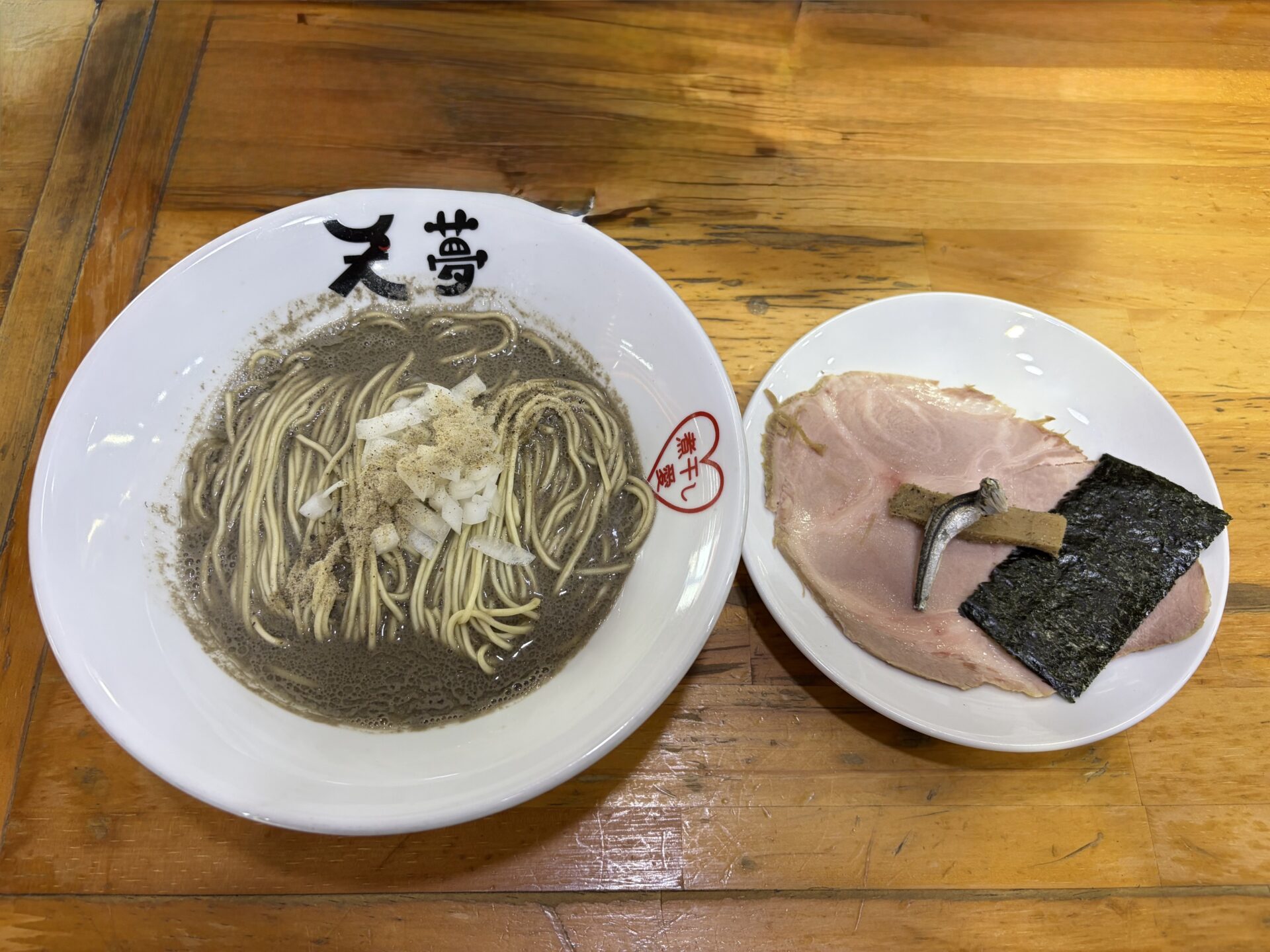 めんや天夢のヤバニボ系の一杯。セメント色の濃厚煮干しスープに細麺と刻み玉ねぎ、チャーシューは別皿