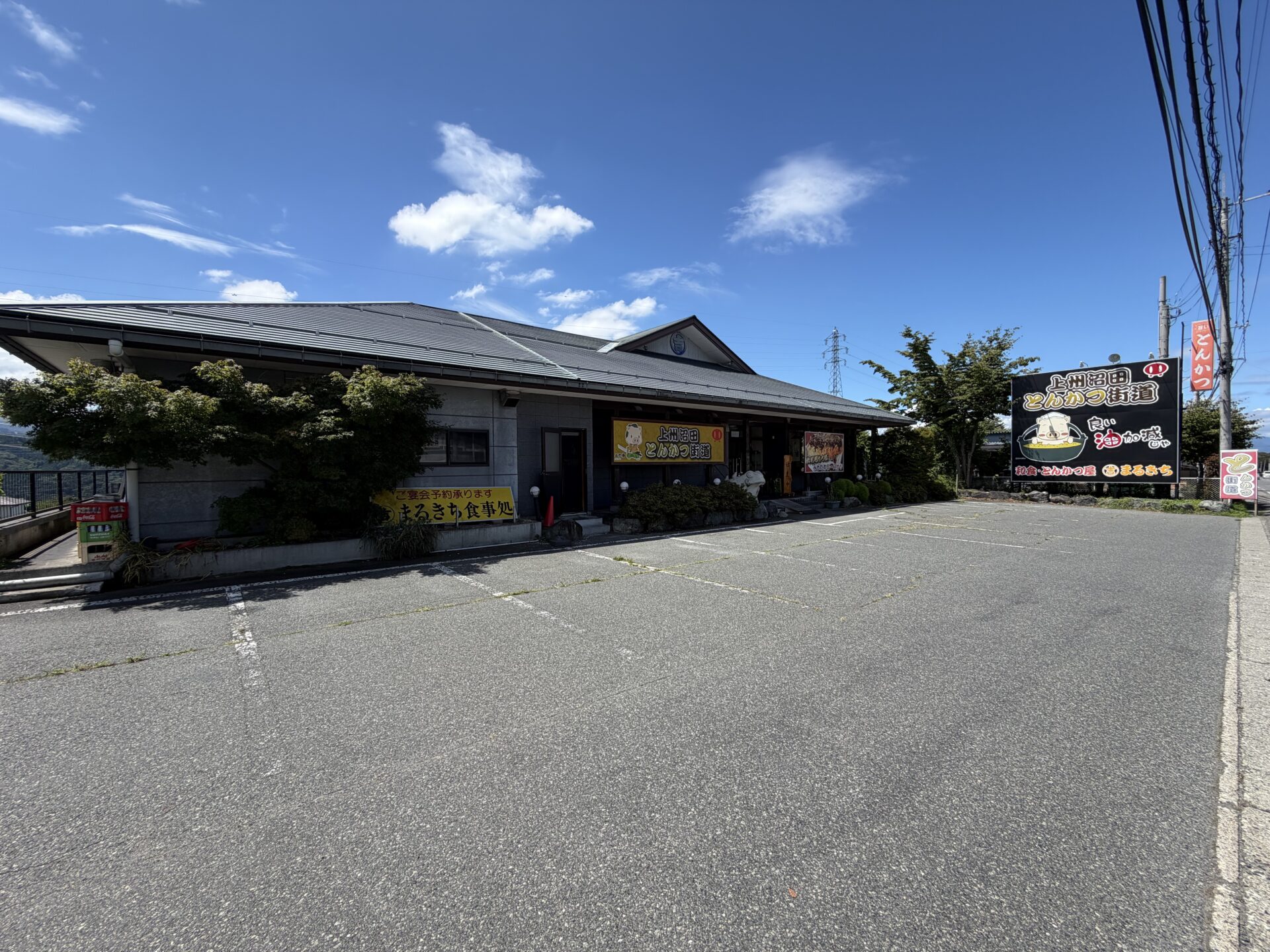 国道120号沿いの外観。「上州沼田とんかつ街道」の大看板と「良い油加減じゃ」の豚キャラ