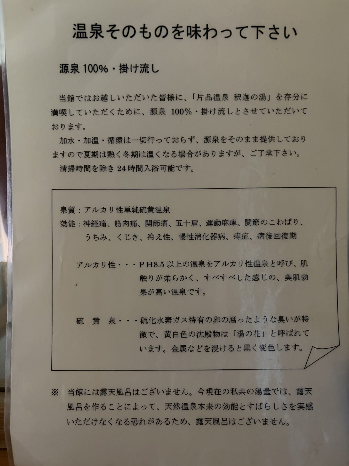 「温泉そのものを味わって下さい」の掲示。源泉100%・掛け流しの説明と、露天風呂を作らない理由