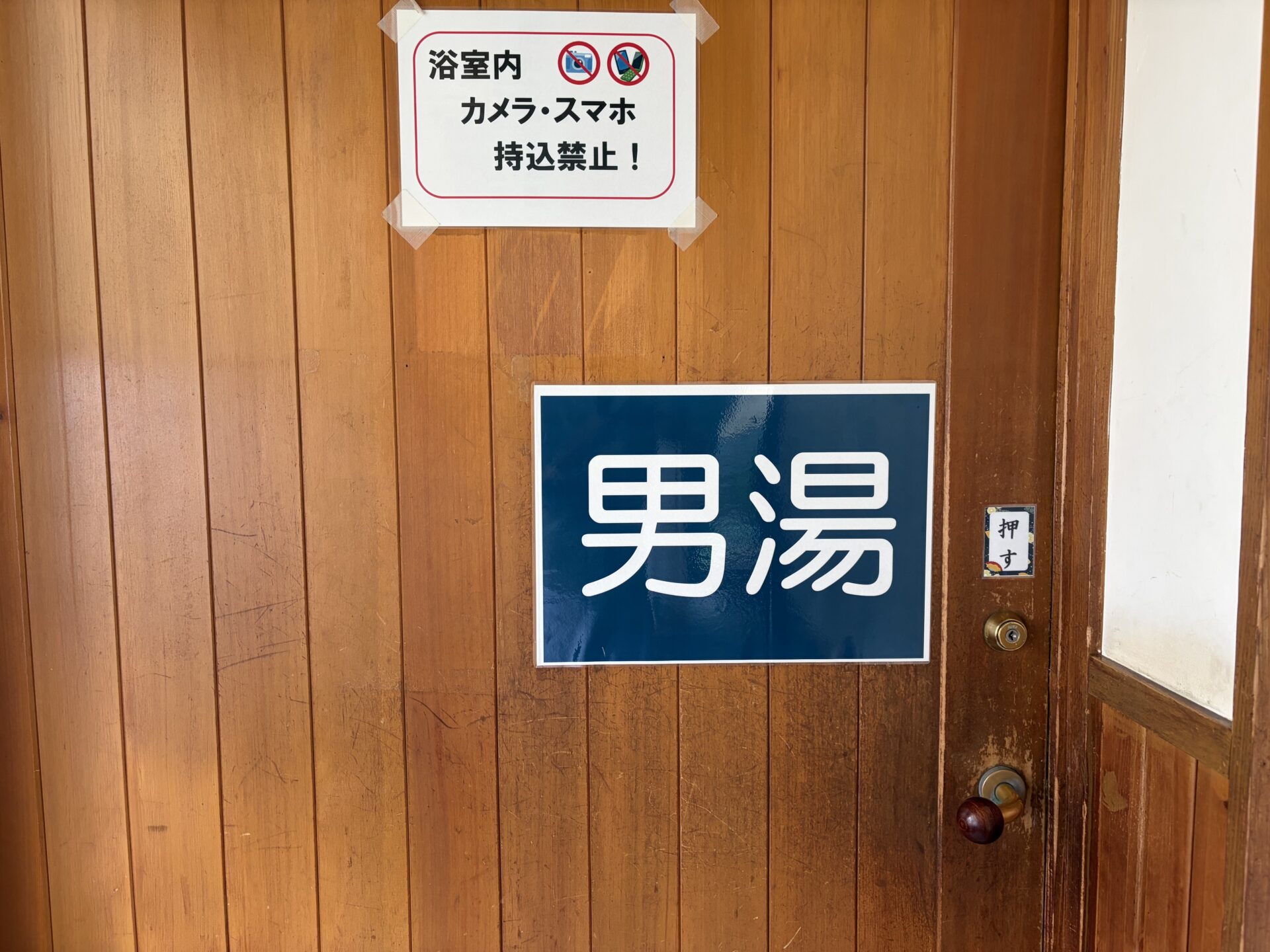 男湯の入口。「浴室内 カメラ・スマホ 持込禁止！」の掲示