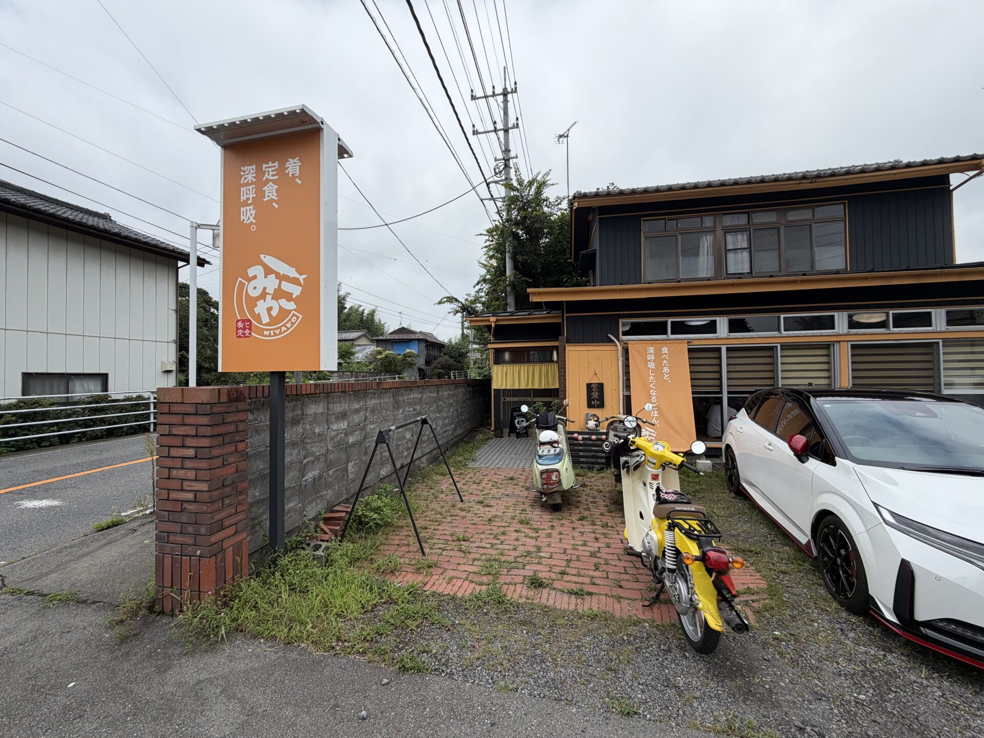 自立看板「肴、定食、深呼吸。」。ロゴはさんまの意匠
