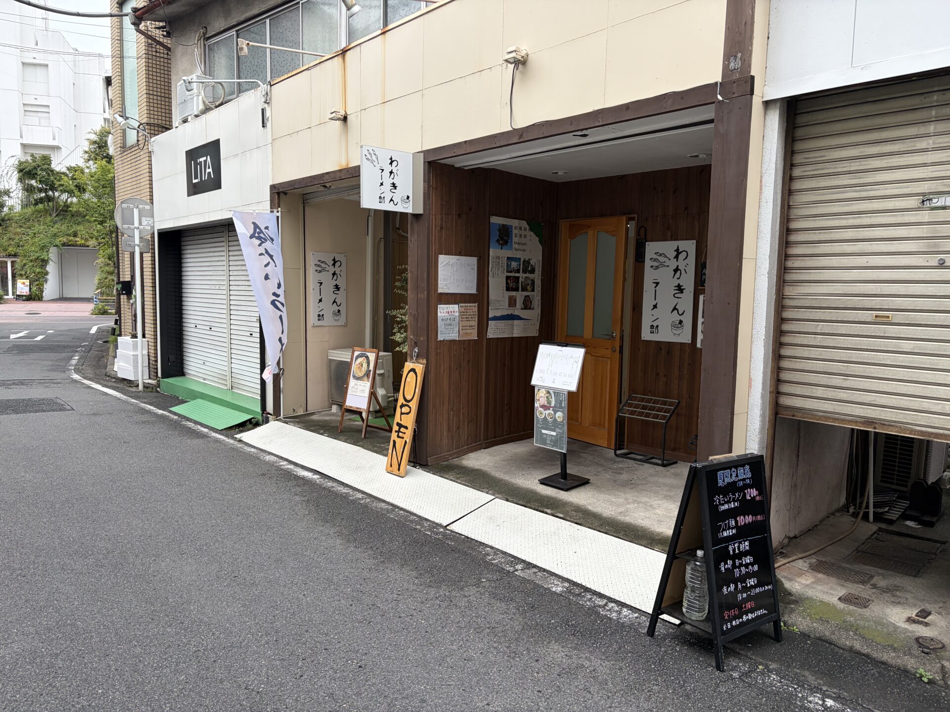 わがきんラーメン部の外観。木の看板とOPENの札