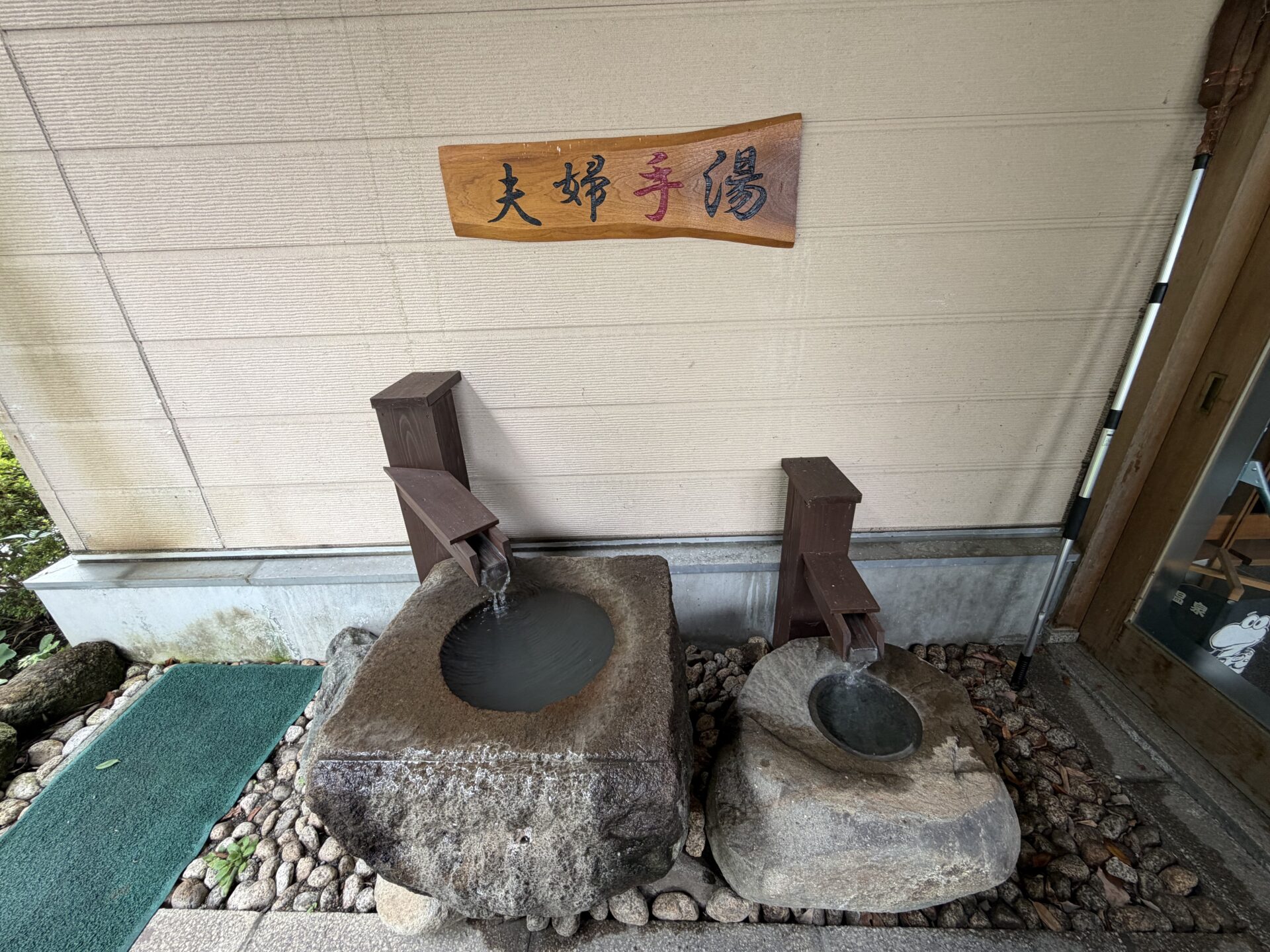 玄関脇の「夫婦手湯」。大小ふたつの石鉢に湯が注ぐ