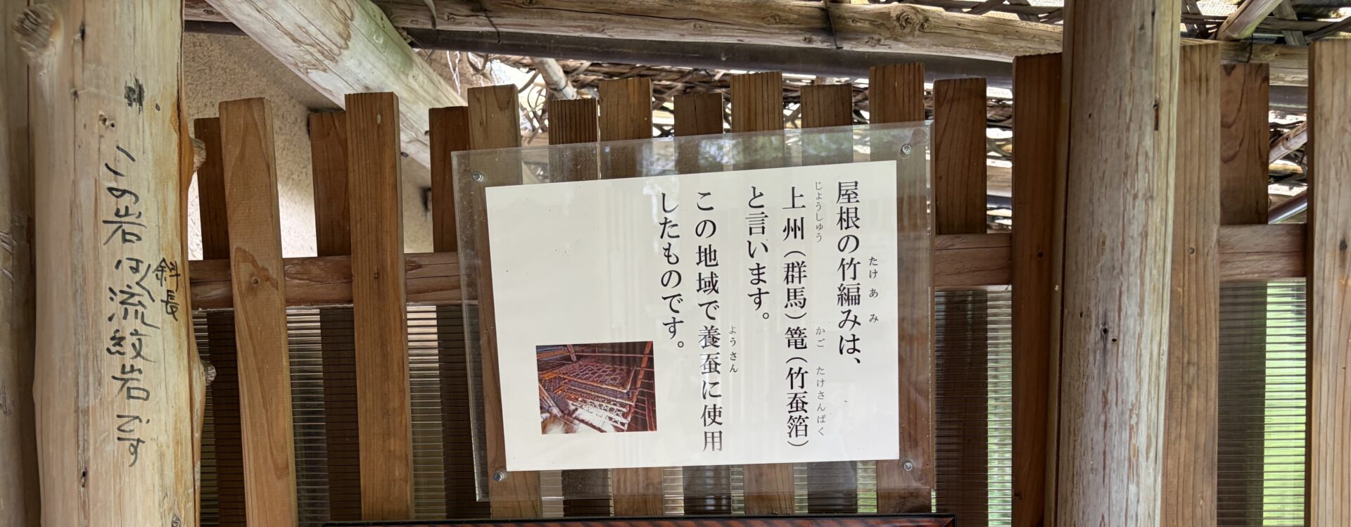「上州篭(竹蚕箔)」の説明板。左の柱に「この岩は斜長流紋岩です」の手書き
