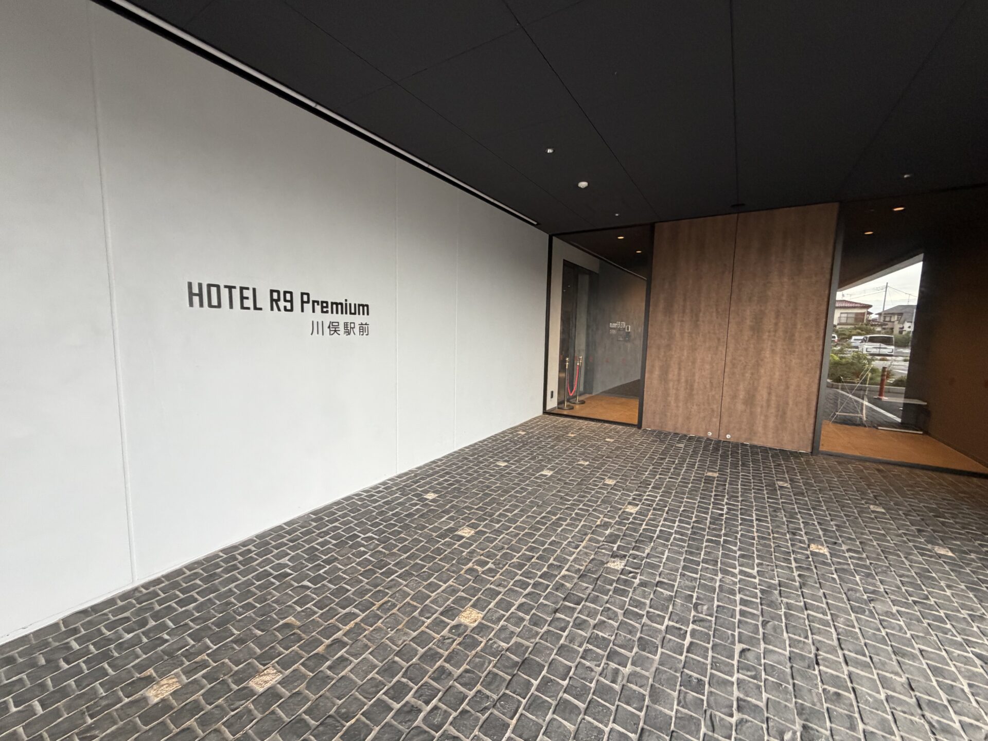 木目の扉に「HOTEL R9 Premium 川俣駅前」のロゴが入ったエントランス