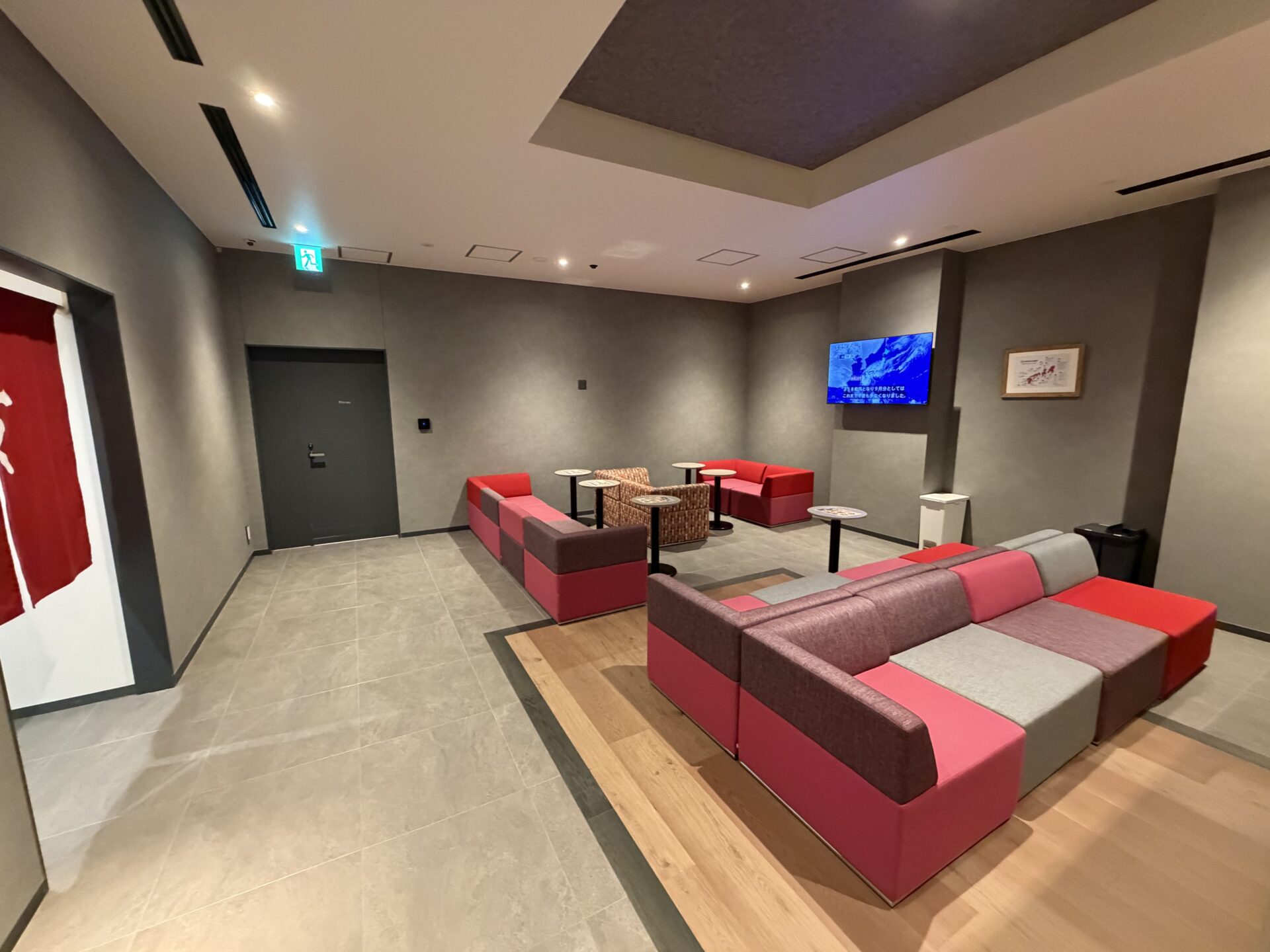 赤いソファとテレビが置かれたラウンジ
