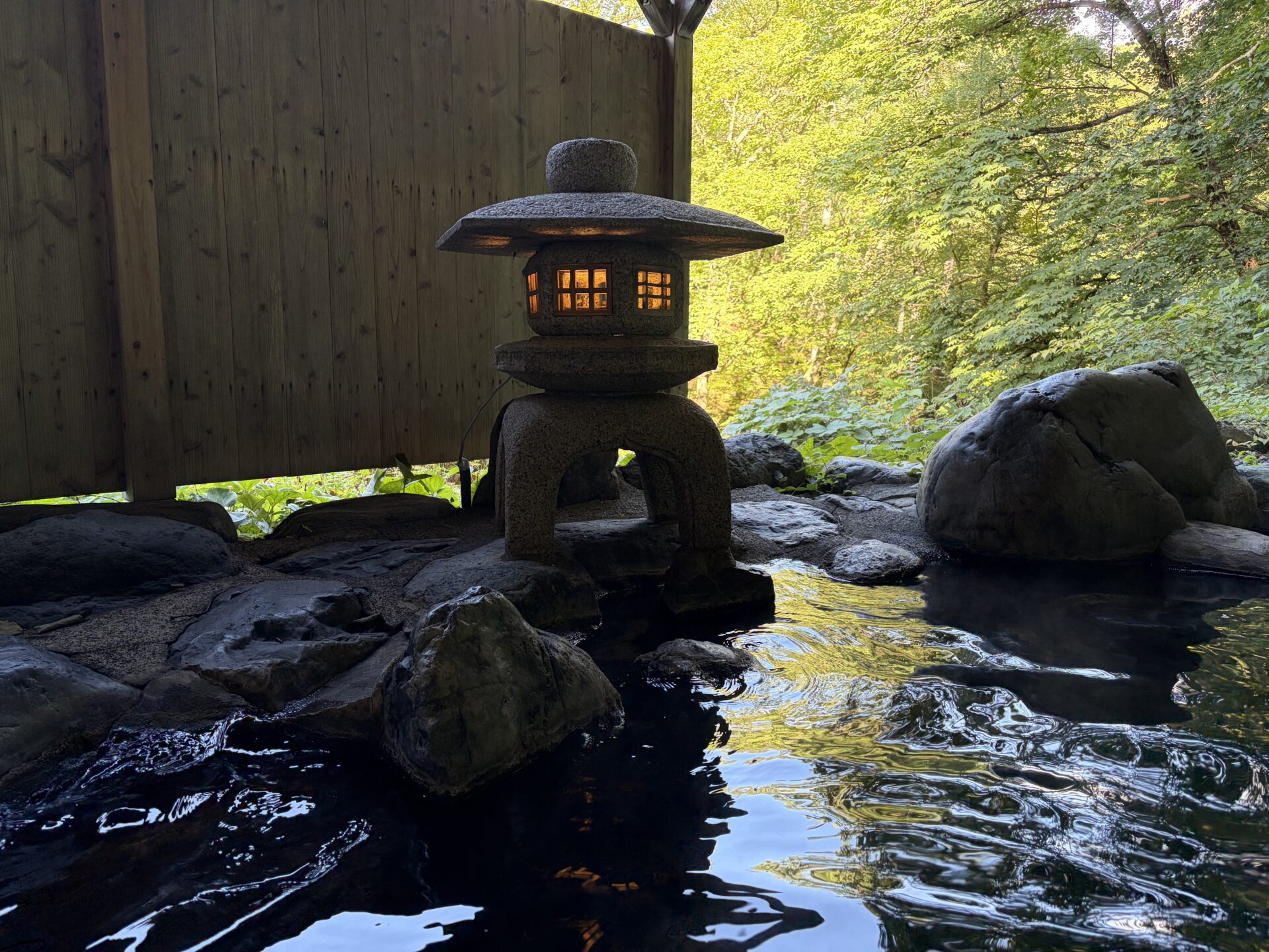 大龍の一角。石灯籠に灯りが入り、岩の間を湯が満たす